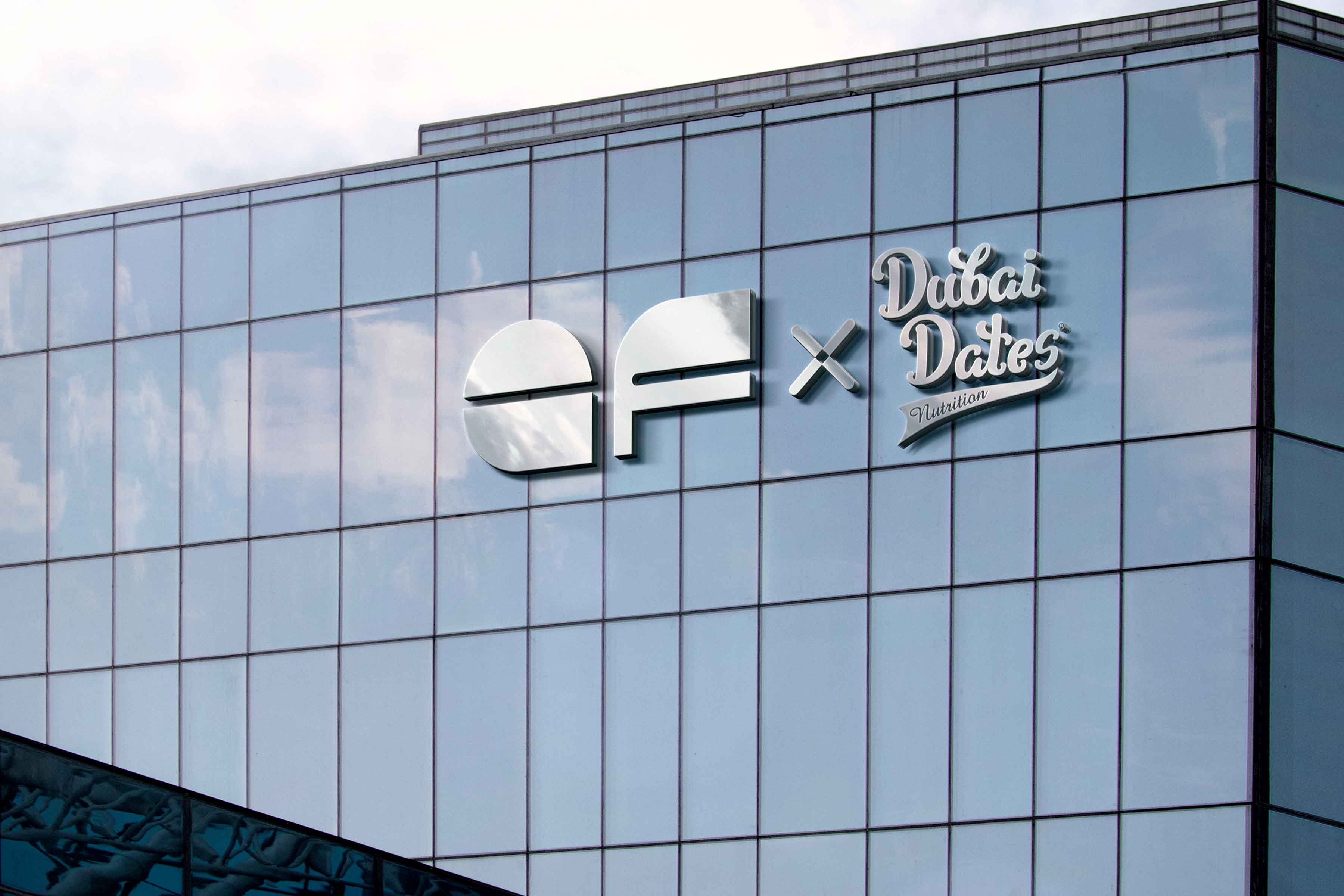 Glass building with Elite Fit and Dubai Dates Nutrition logo on a metal signage.