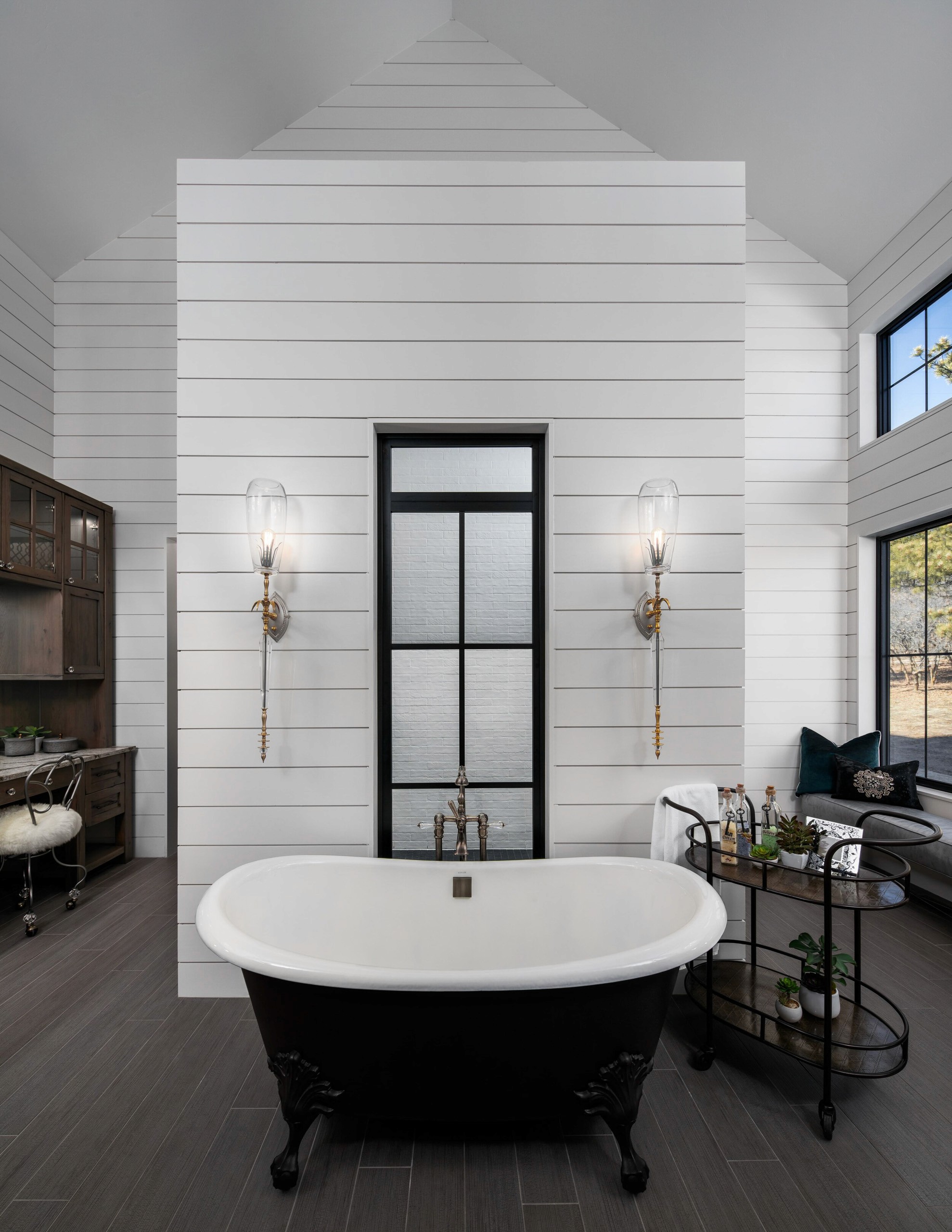 Ornate black clawfoot tub with shiplap walls.