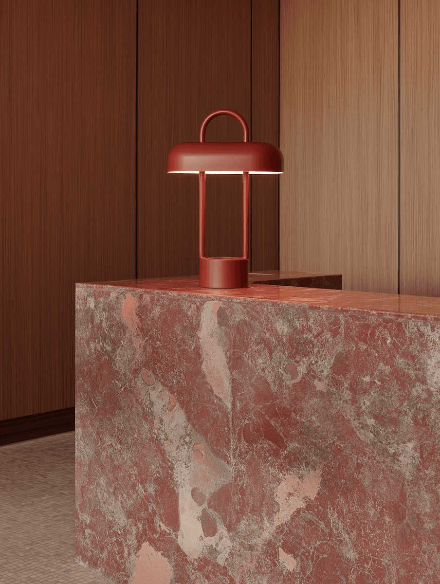 Red table lamp on a pink stone counter in a wood-panelled interior