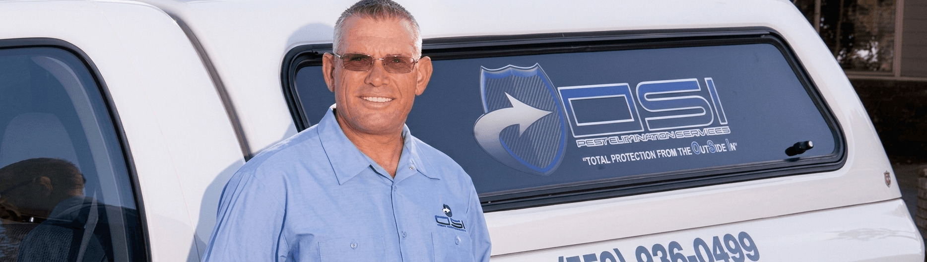 Owner of OSI Pest Elimination standing beside company service vehicle in pest control uniform.
