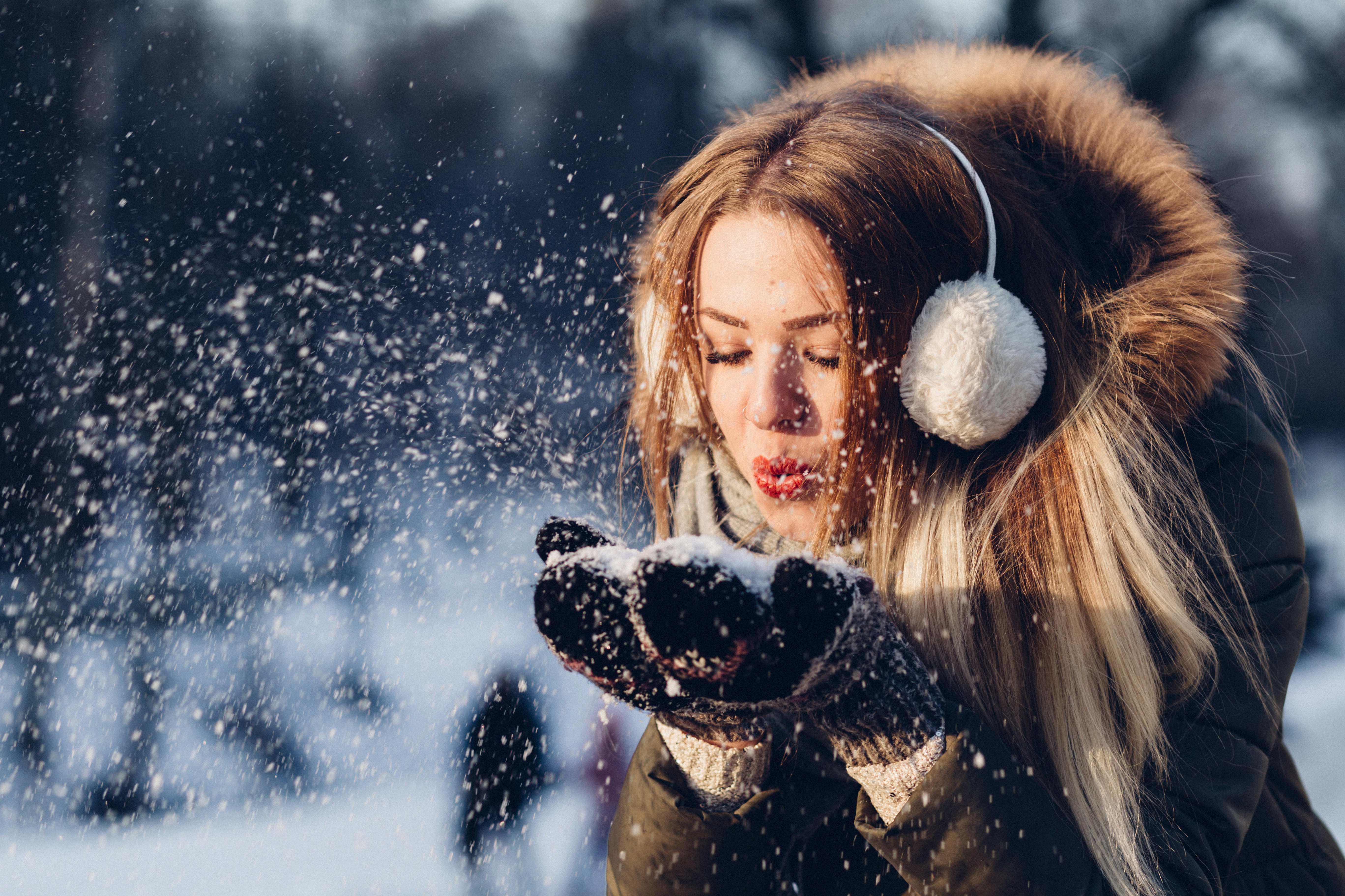 Girl blowing Snow - Winter Skincare Routine