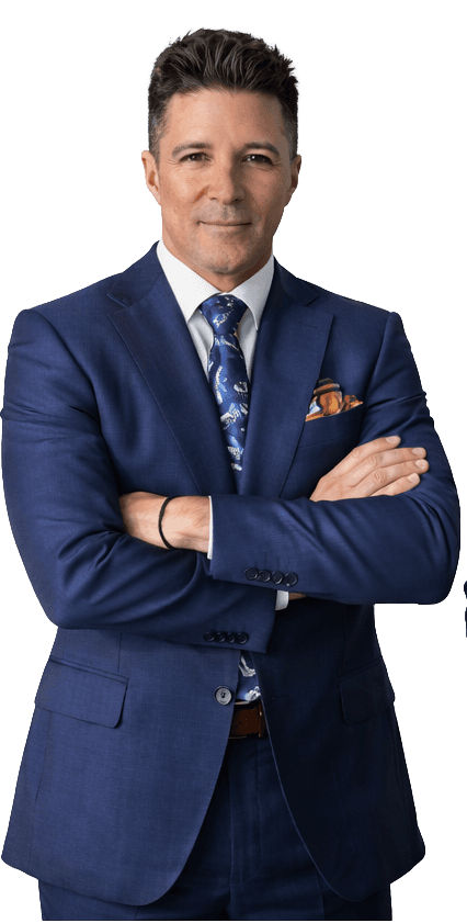 Asian man with glasses in a creative workspace, surrounded by colorful abstract art and stationery on a cluttered desk.