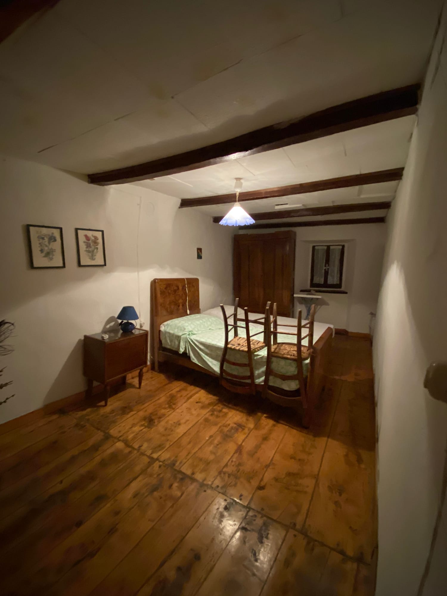 Bedroom before the renovation, with old furniture and a wooden floor