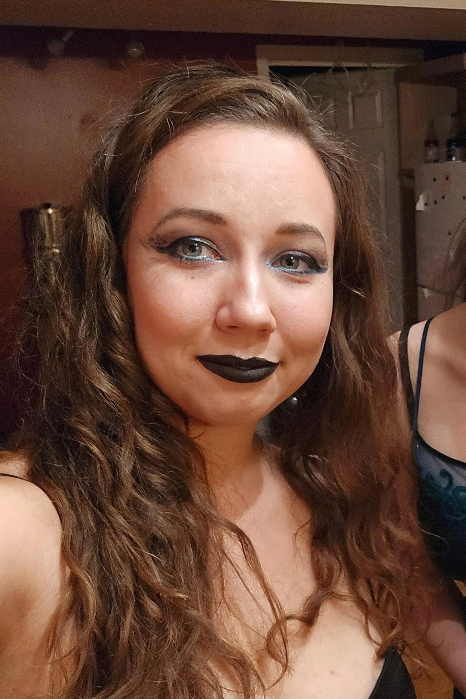 A bride in a white lace wedding dress holds a colorful bouquet of pink, yellow, and orange flowers.