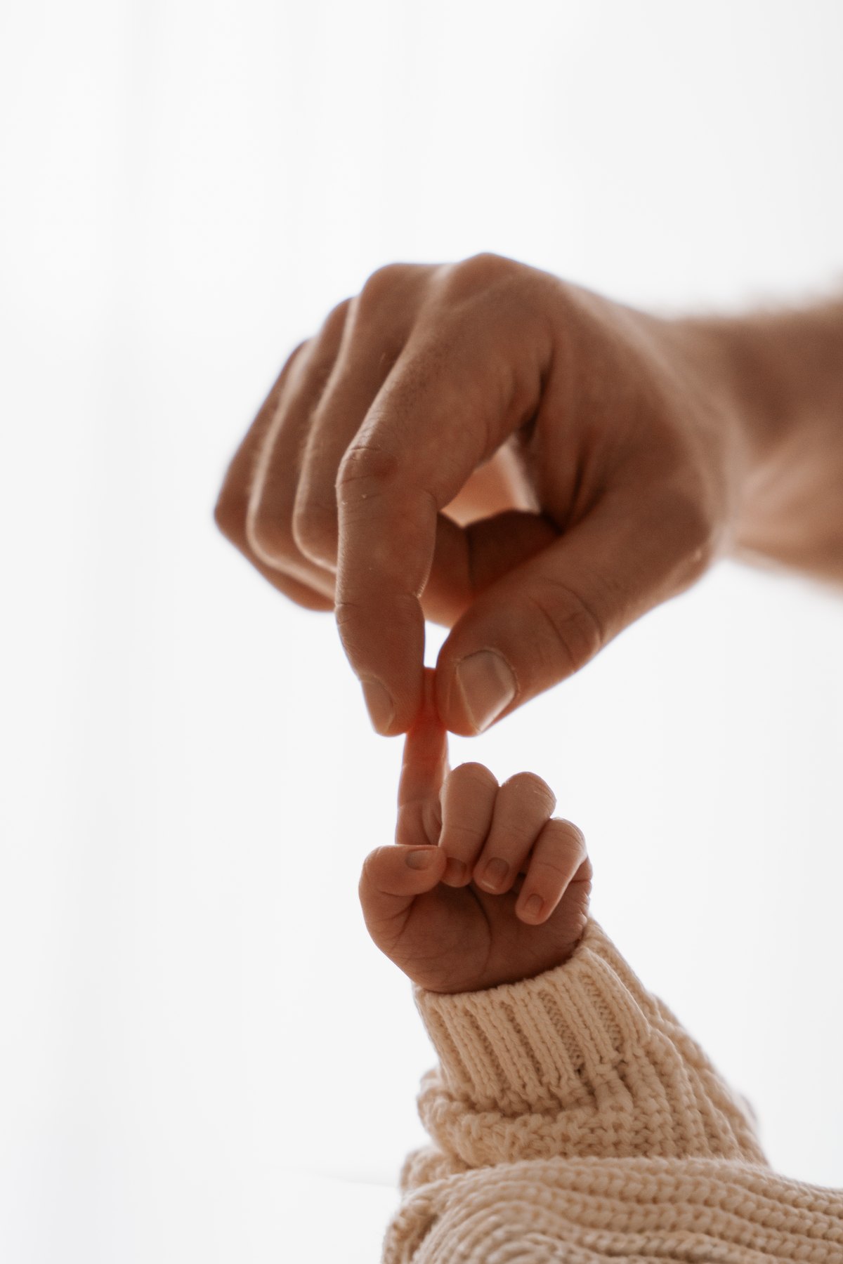 Hand einer Erwachsenen und winzige Babyhand