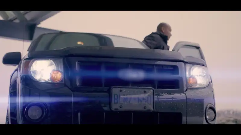Cox Automotive colleague standing beside a vehicle outdoors in cold weather conditions.