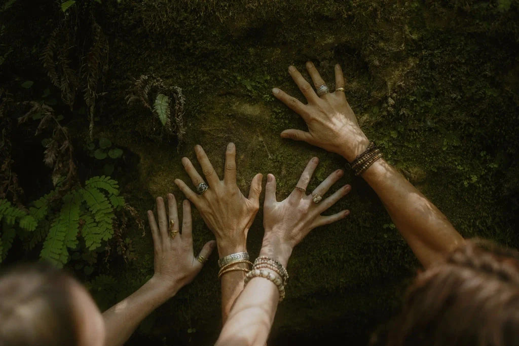 Hands pressed into earth representing individual sovereignty and grounding
