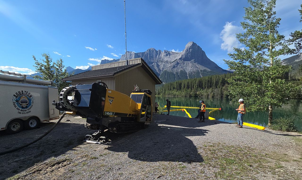 Horizontal directional drilling equipment and turbidity curtain at Canmore Nordic Centre water intake construction site