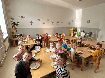 Děti společně svačící u stolečků