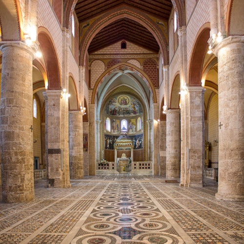 宏伟教堂的内部装饰有华丽的柱子、精致的地板砖,以及背景中明亮的祭坛。