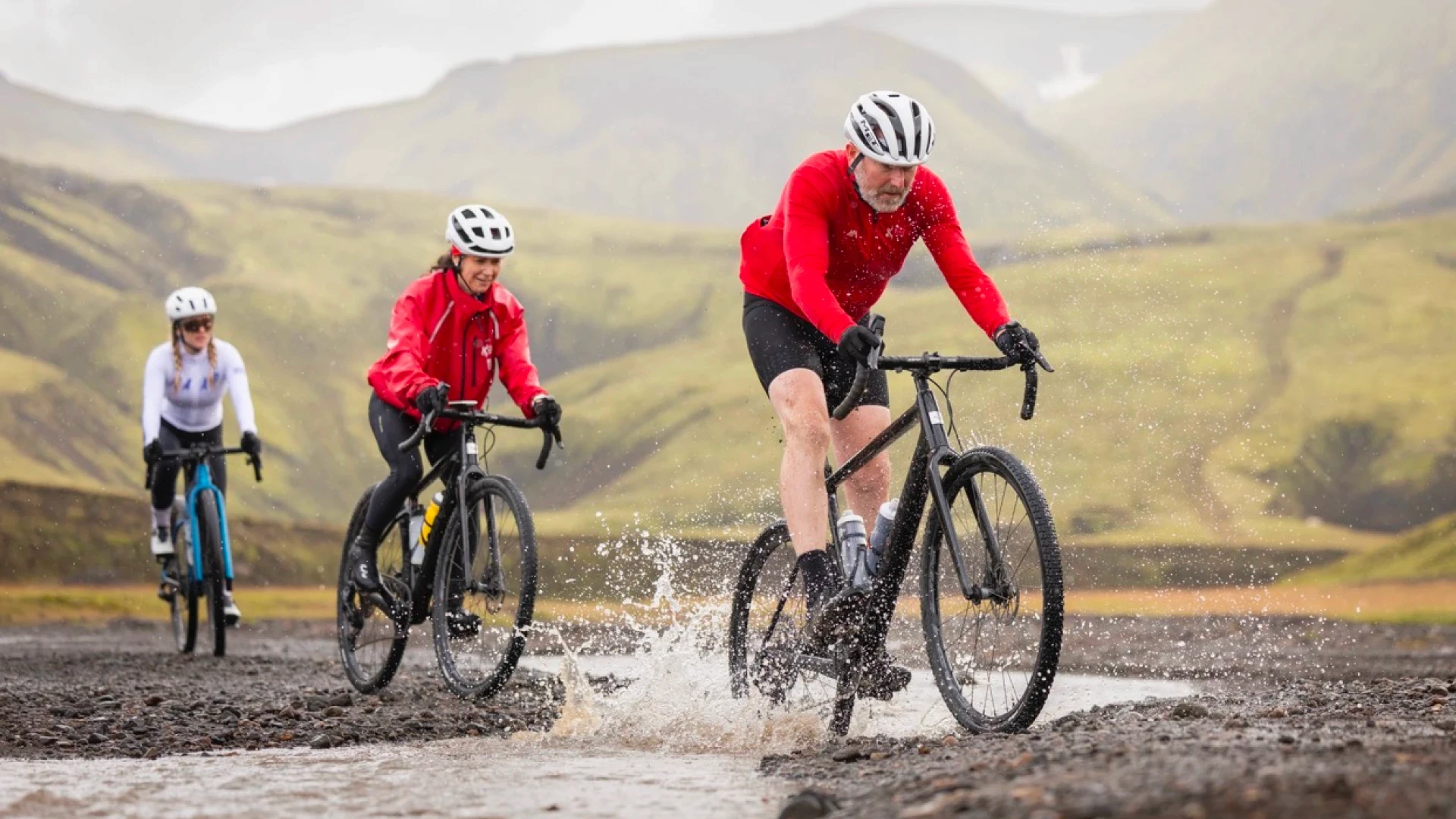 men cross river on a bike in Iceland