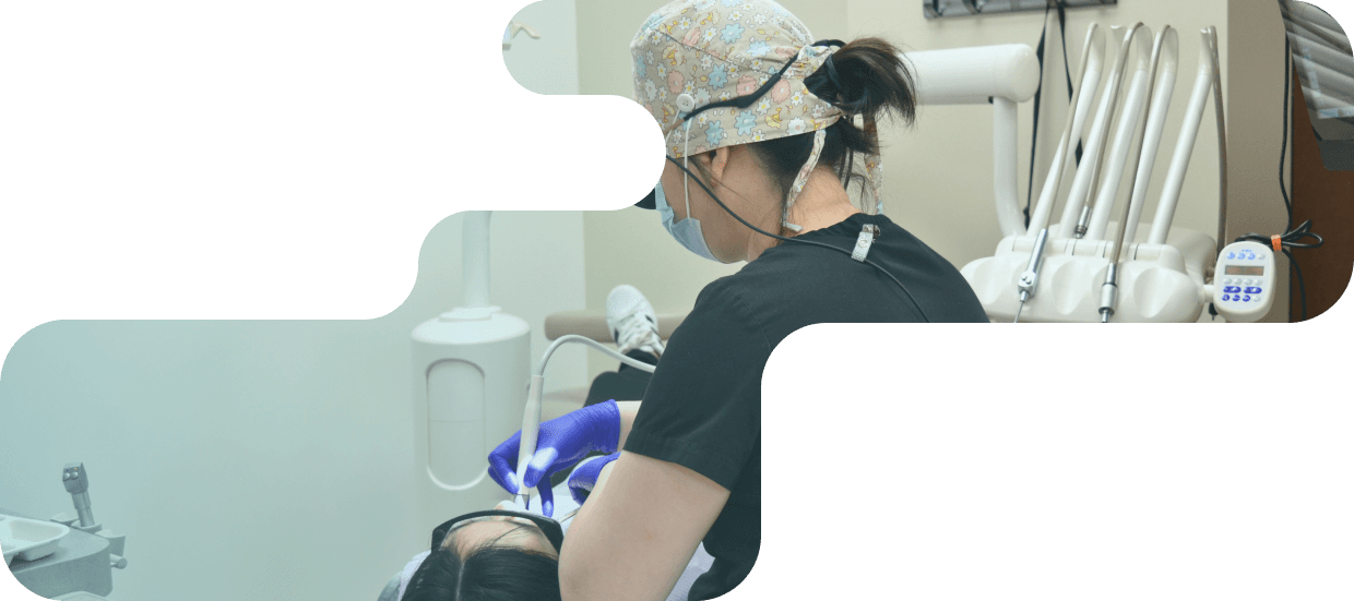 A dental professional in a colorful cap and mask performing a dental procedure on a patient at Metro Pointe Dental.