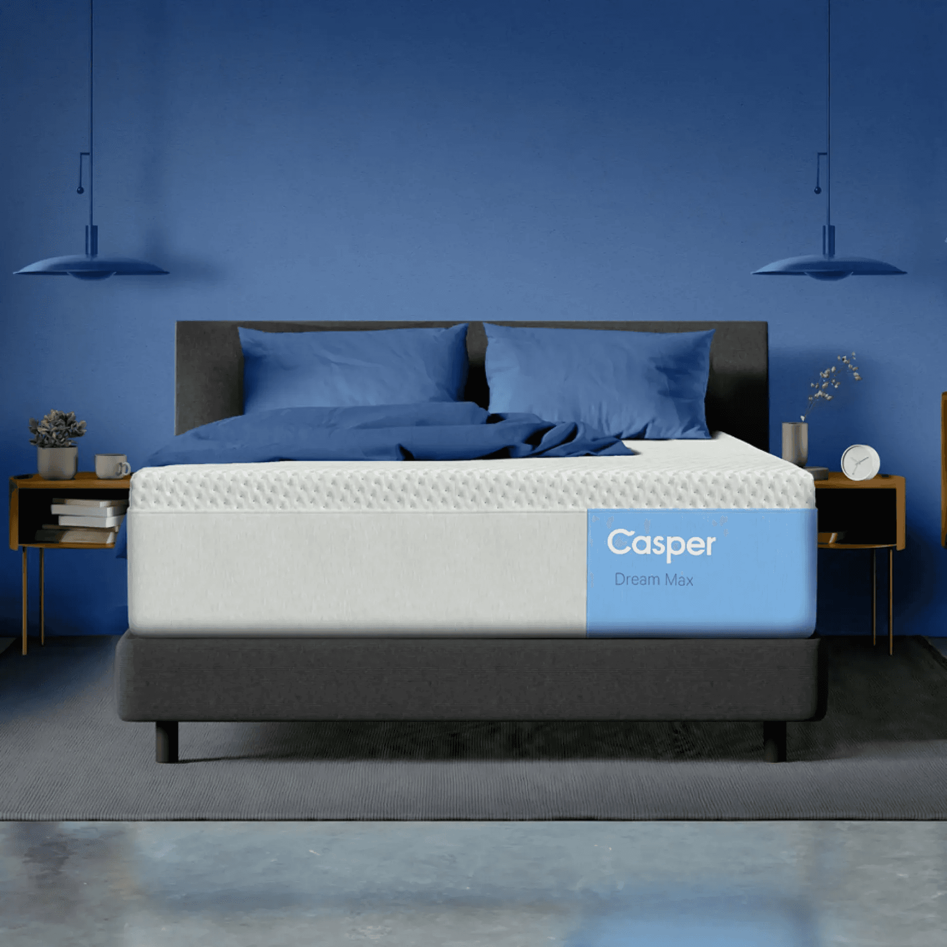 A Casper Dream Max mattress setup against a deep blue accent wall, showing a premium comparison option in the newcomer mattress guide. The blue and white Casper branding is visible on the mattress.