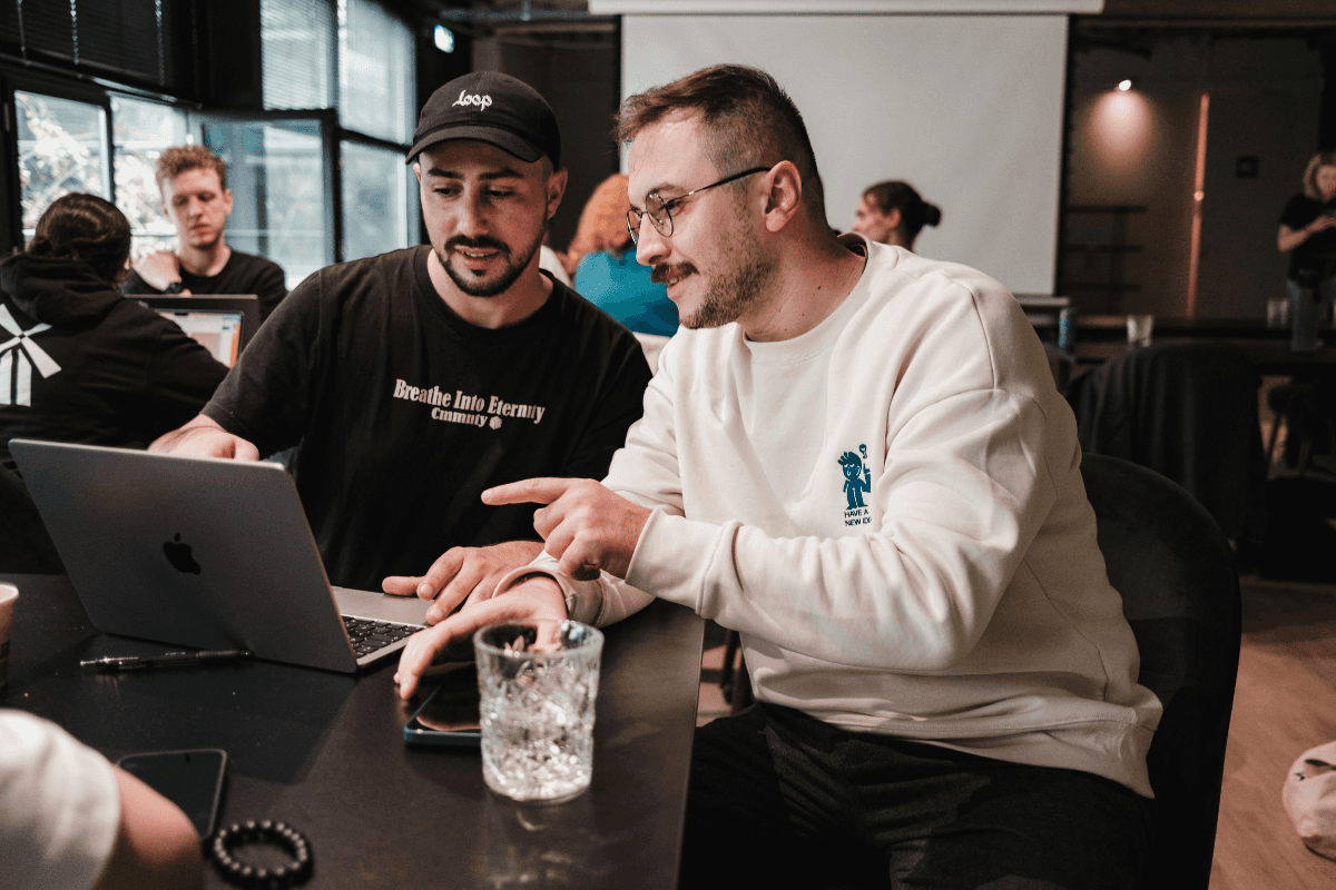 Two people using a laptop in an office.