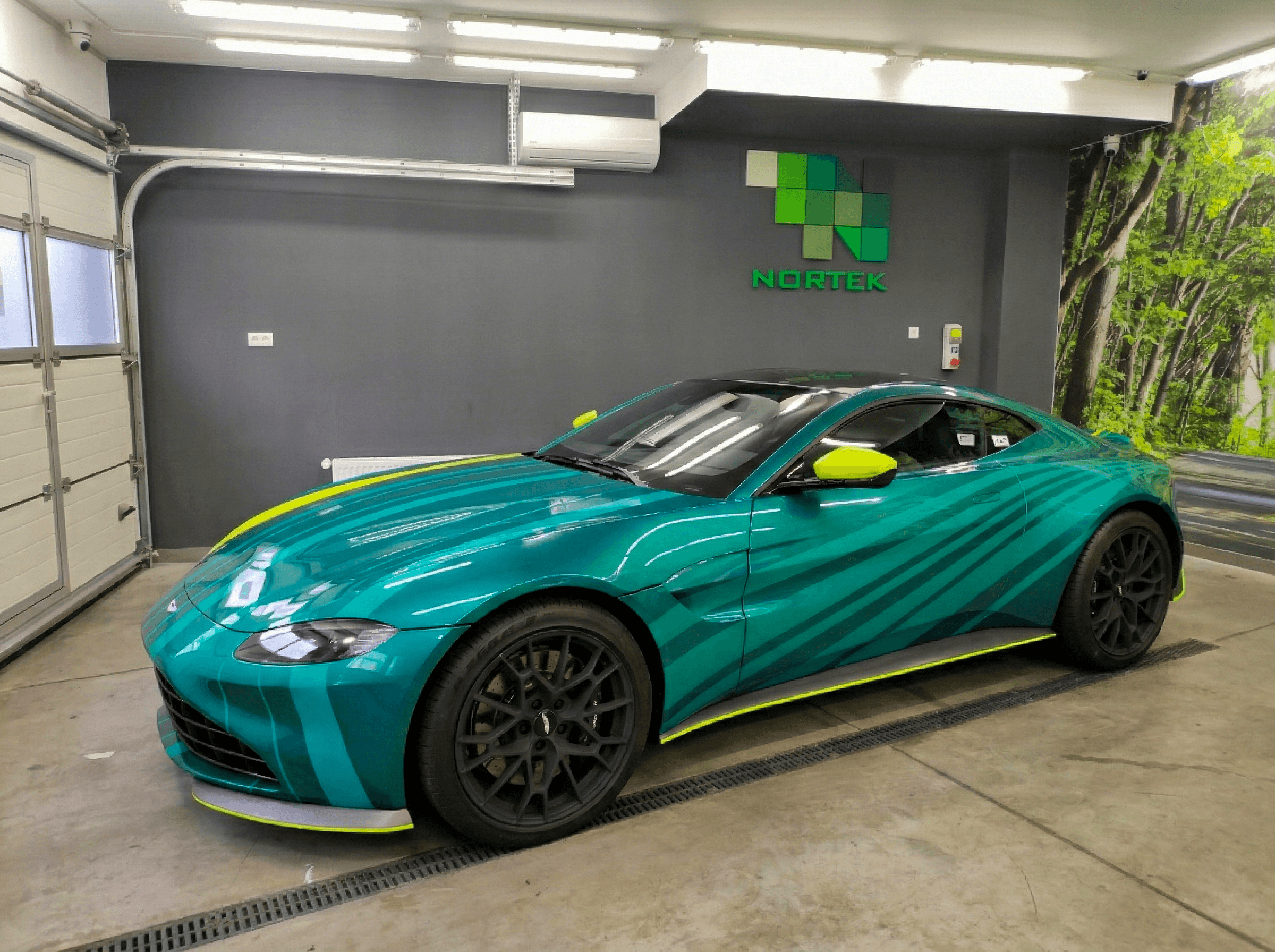 Lélegzetelállító egyedi F1 autógrafika (racing livery) egy Aston Martin Vantage sportautón. A dinamikus, világoszöld és neon sárga sávos dizájn tökéletesen kiemeli az autó sportos vonalait.