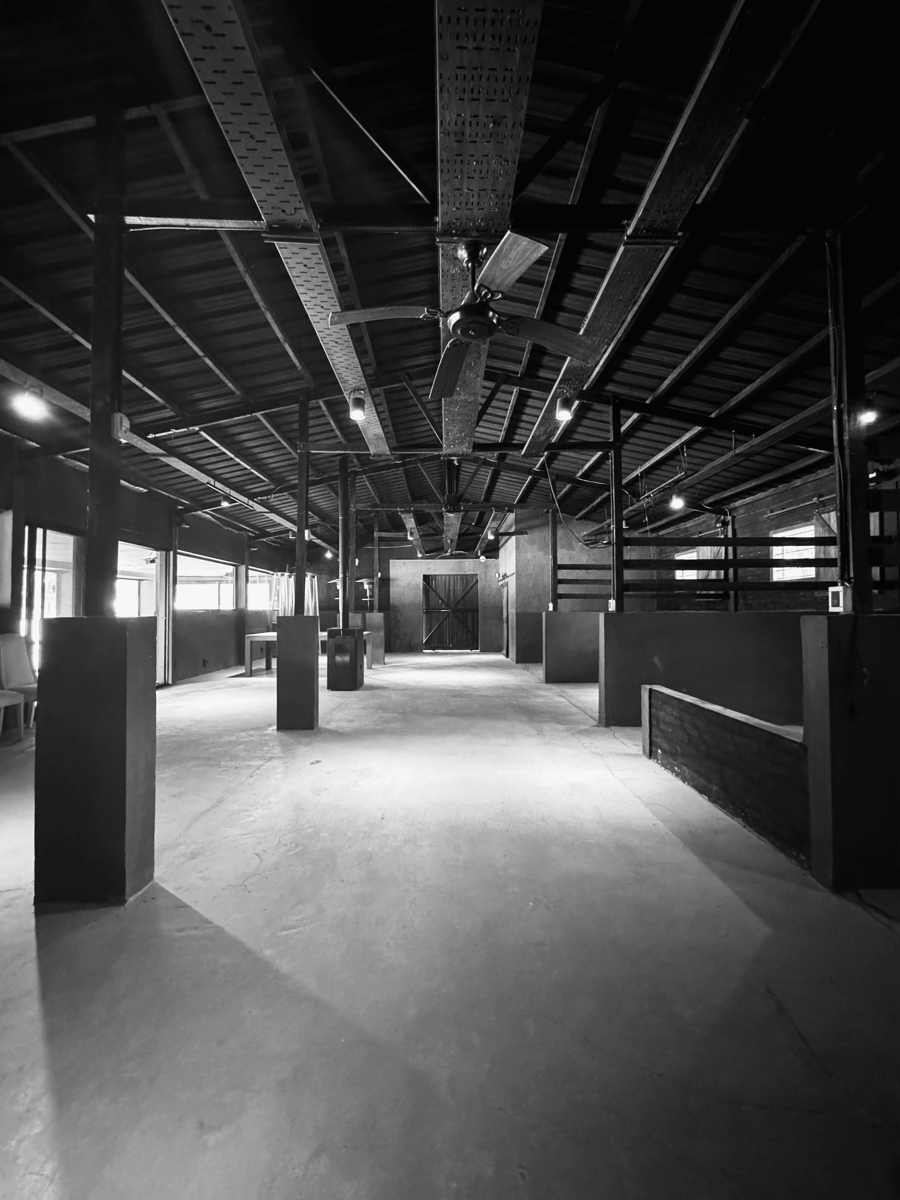 A smiling young man with crossed arms, wearing a plaid shirt and white t-shirt, poses against a dark background.