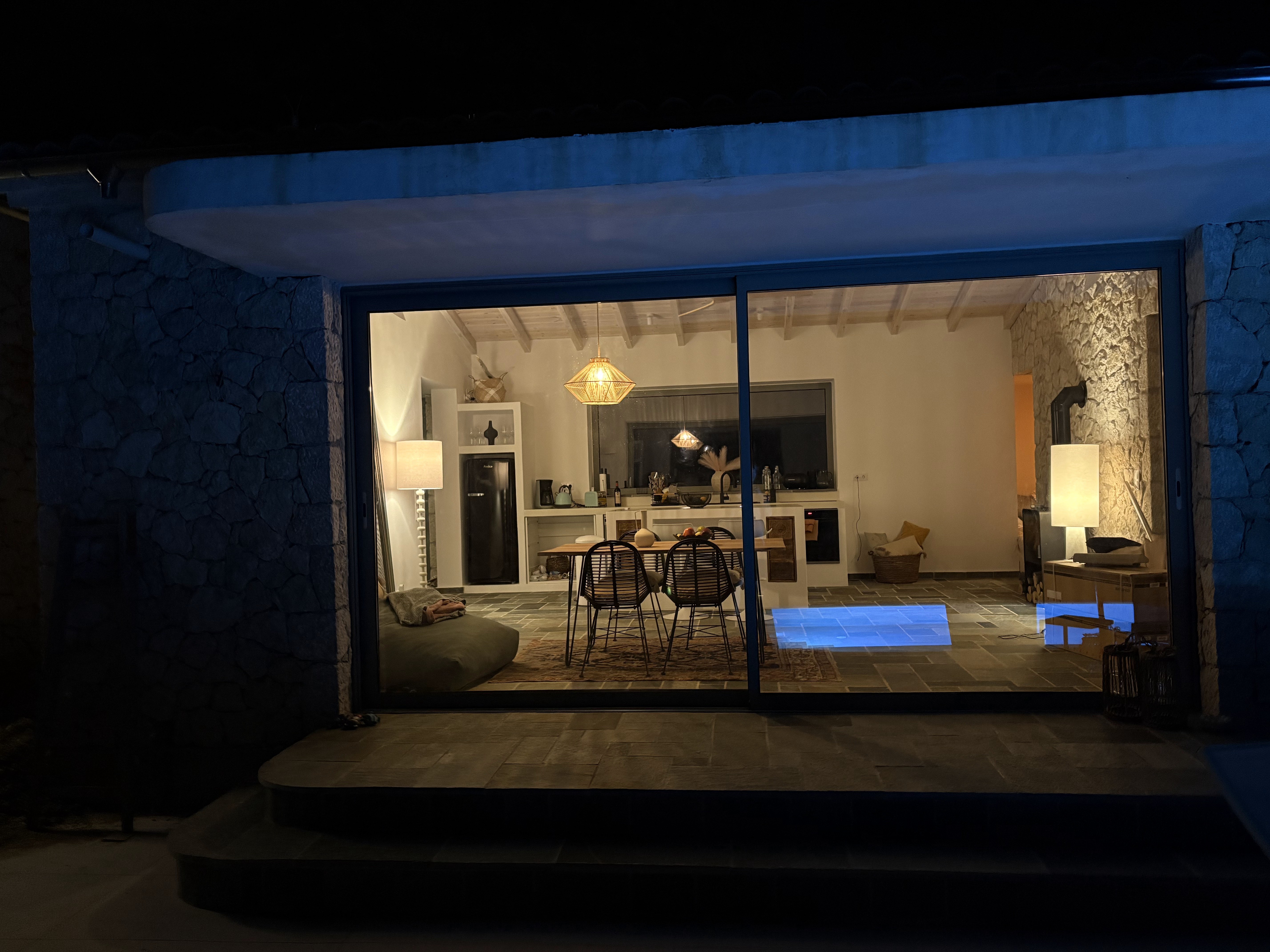 Night view of Loulis House with illuminated pool and terrace.