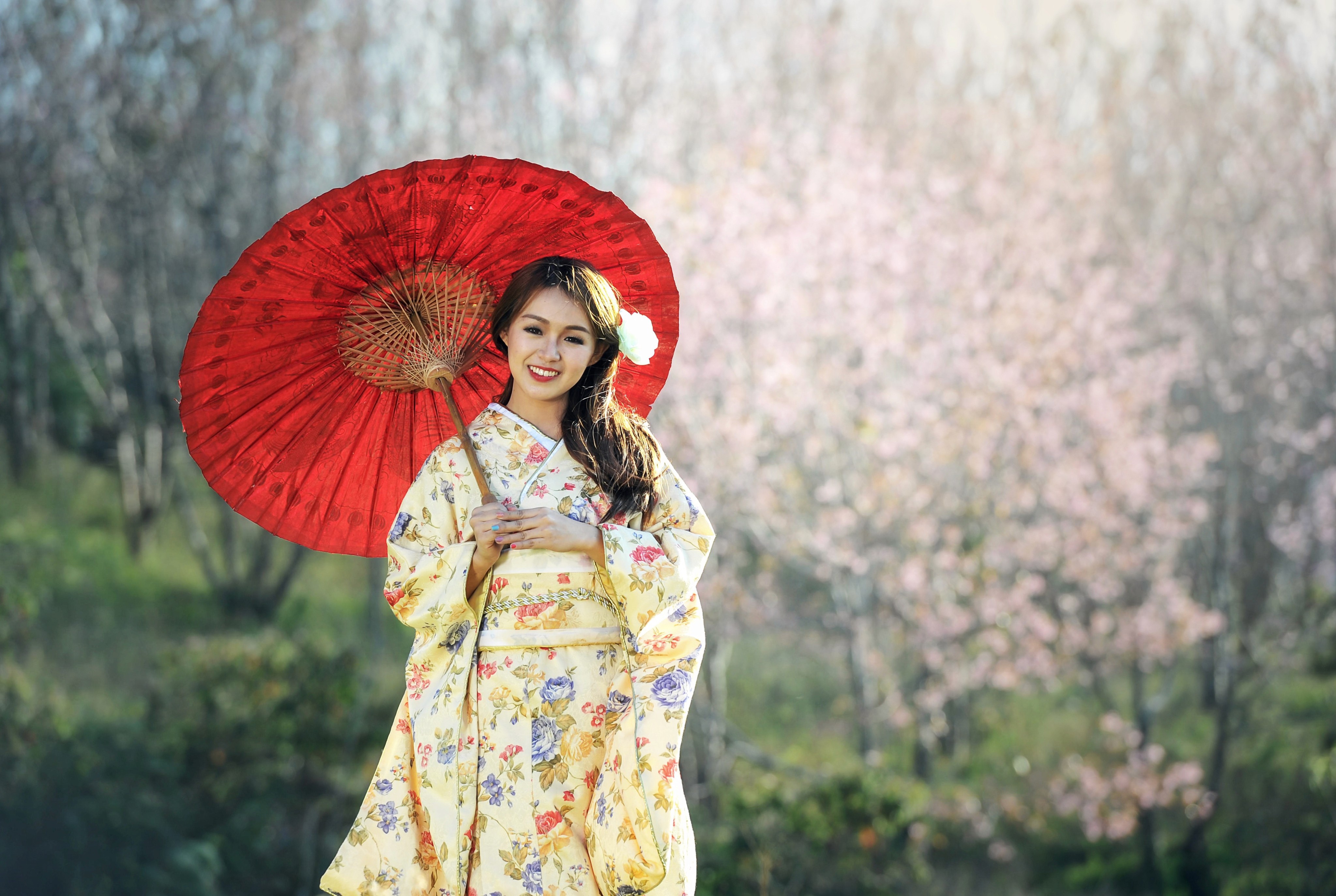 A girl in traditional Japnaese kimono, holding a red umbrella