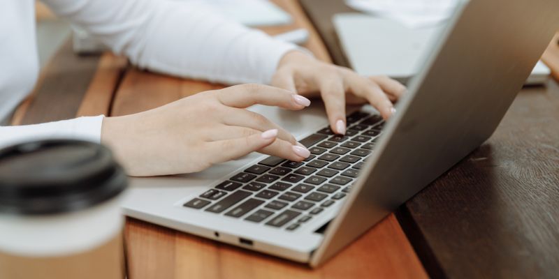 A Malaysian woman typing on her laptop