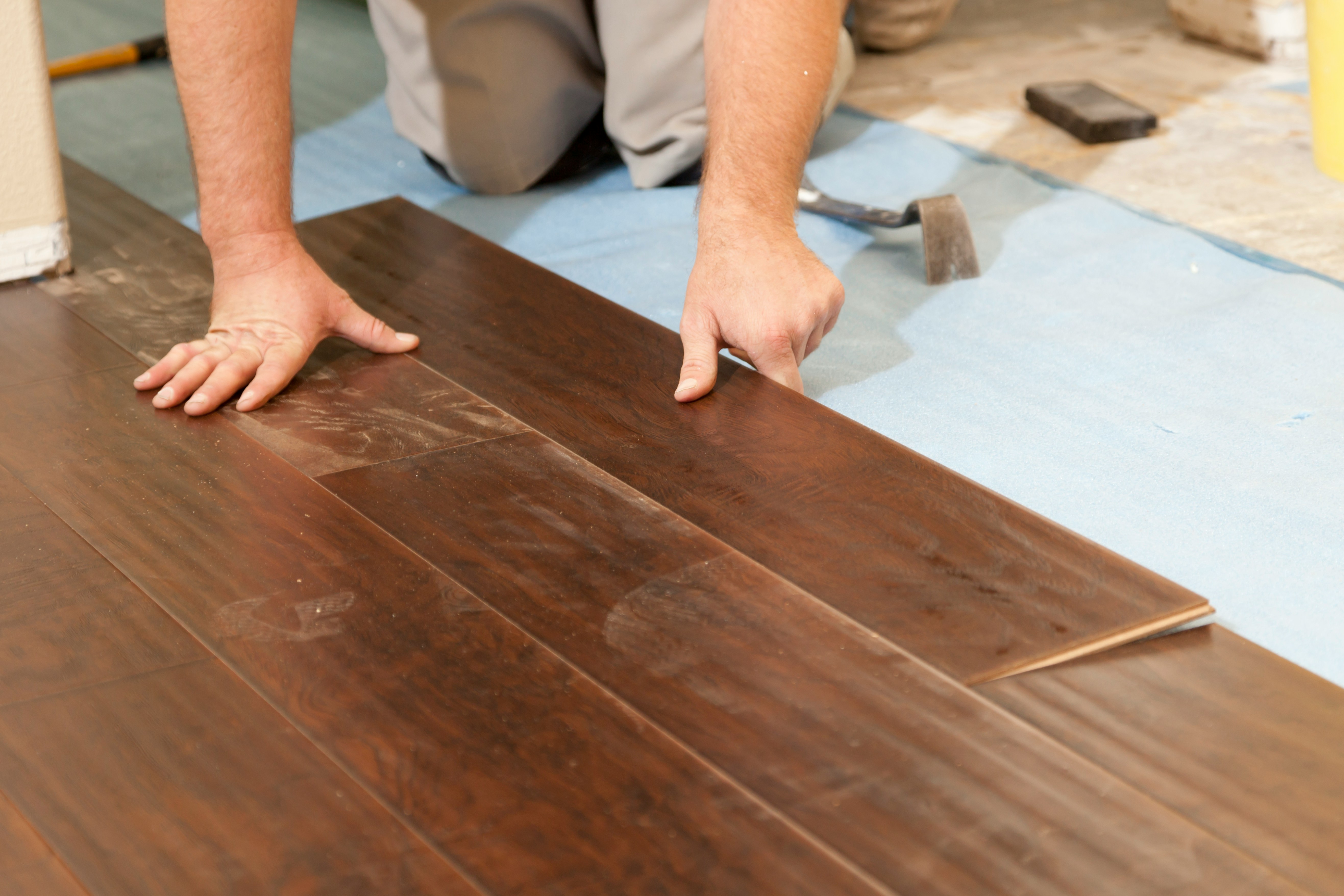 woman in gray shirt sitting on brown wooden floor
