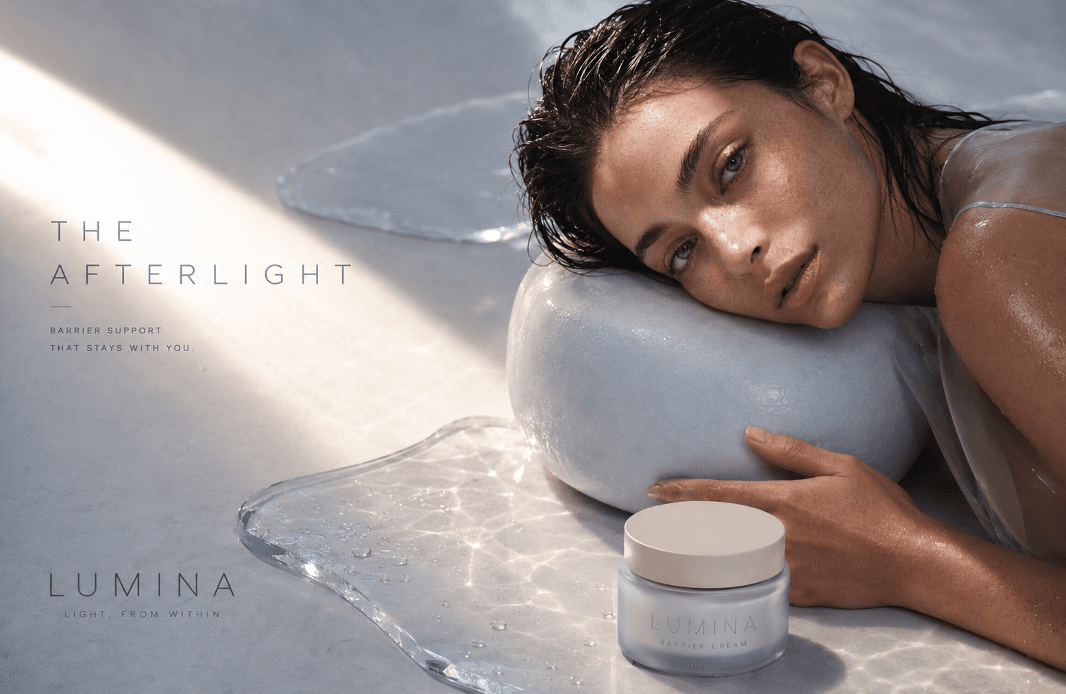 Lumina skincare campaign featuring a model resting on a translucent blue form beside the Barrier Cream jar.