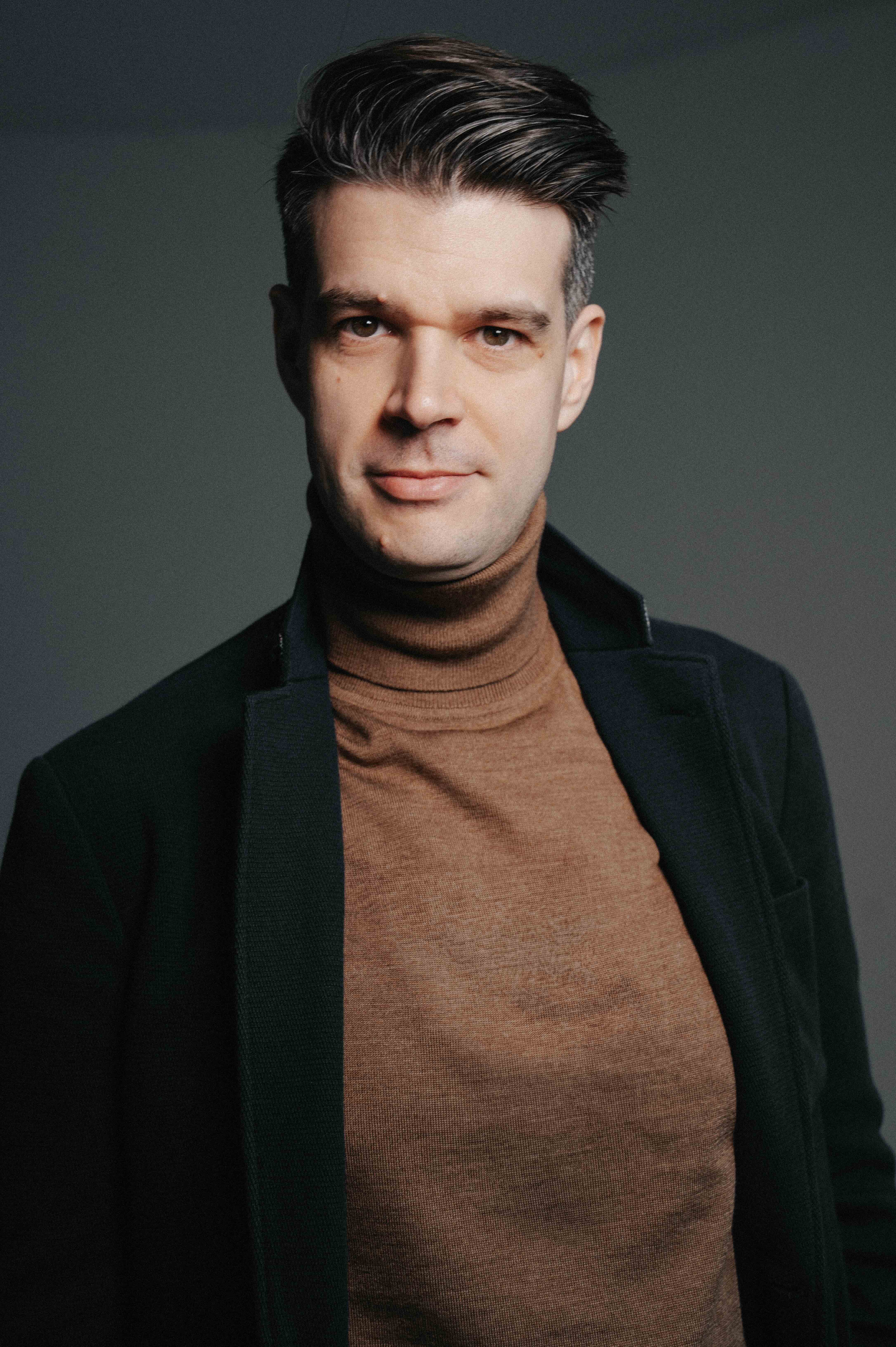 Mann mit dunklem Sakko blickt in die Kamera