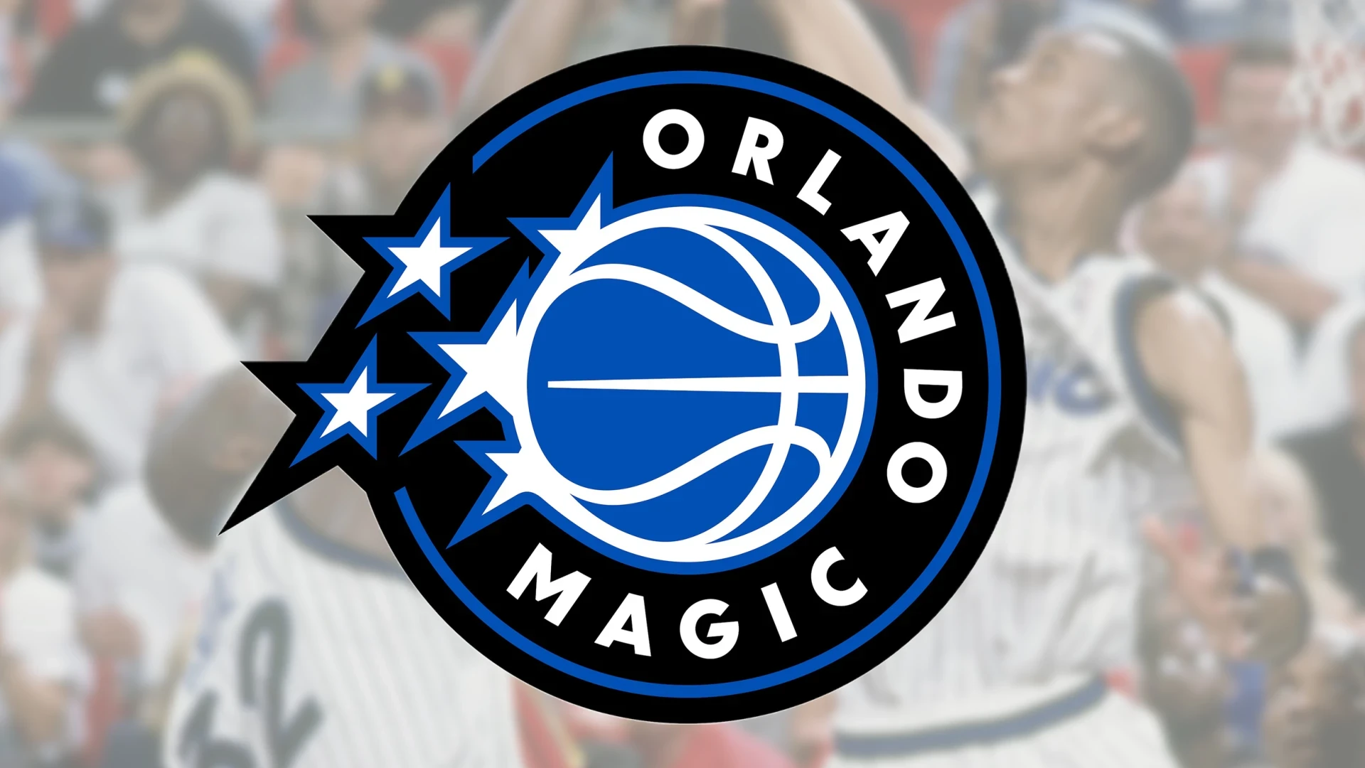 Close up of the Orlando Magic team logo featuring a blue basketball with stars on a black and white circular background.