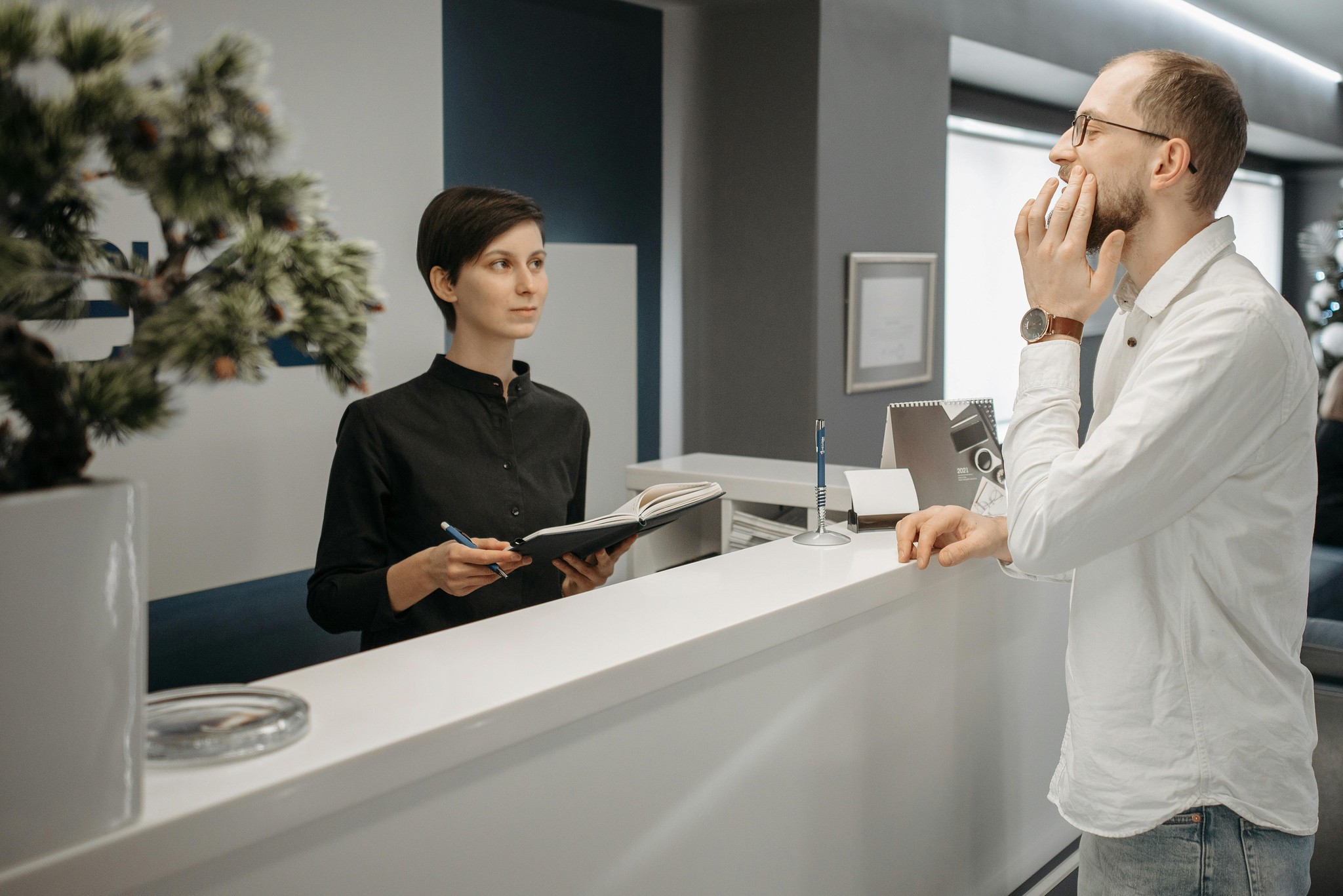 An office space with one person talking to another behind a desk
