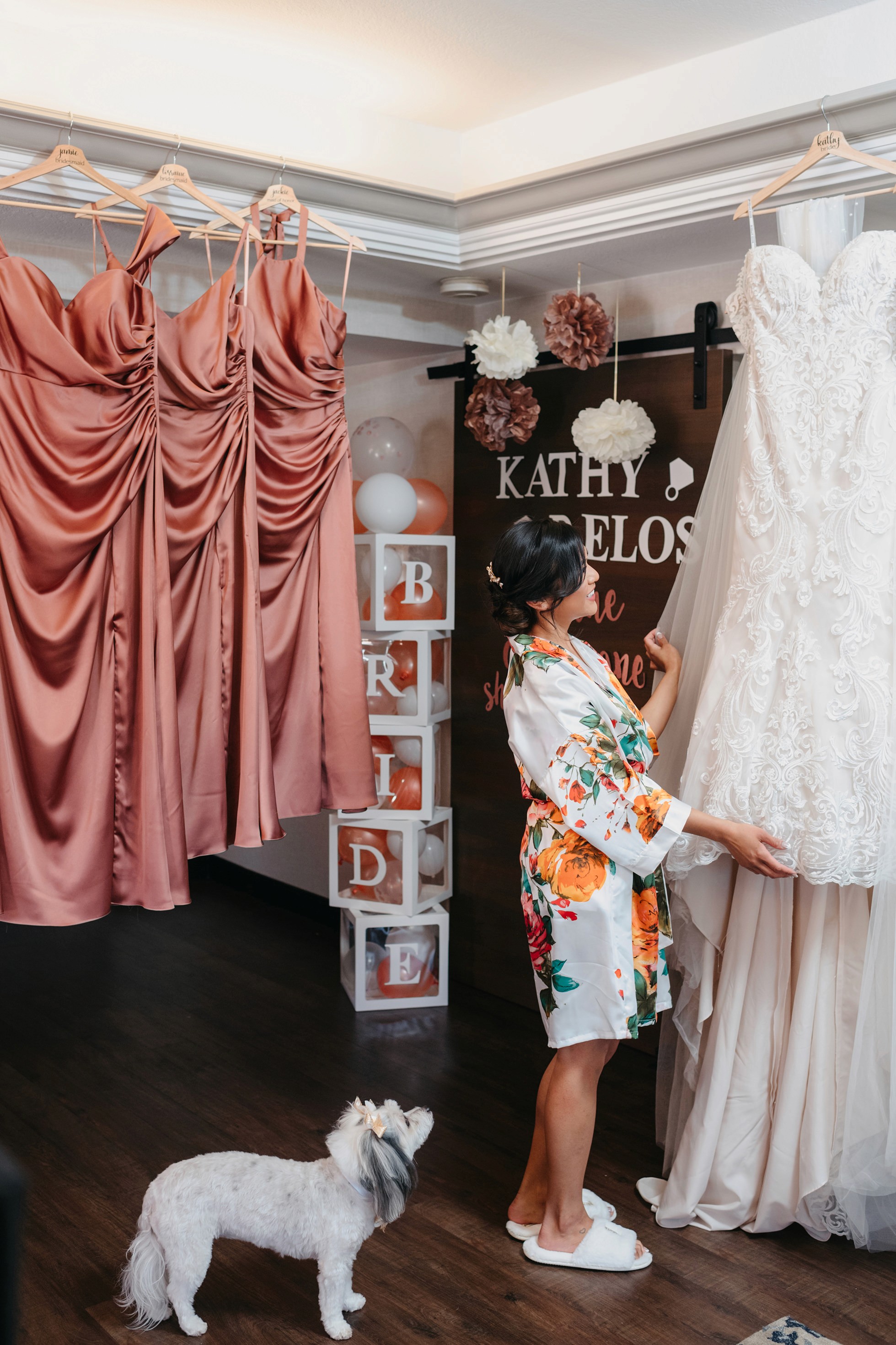 Bridesmaids in floral robes celebrating with the bride during wedding morning prep