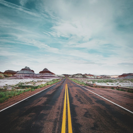 Straight desert highway representing long-haul trucking travel and safety awareness