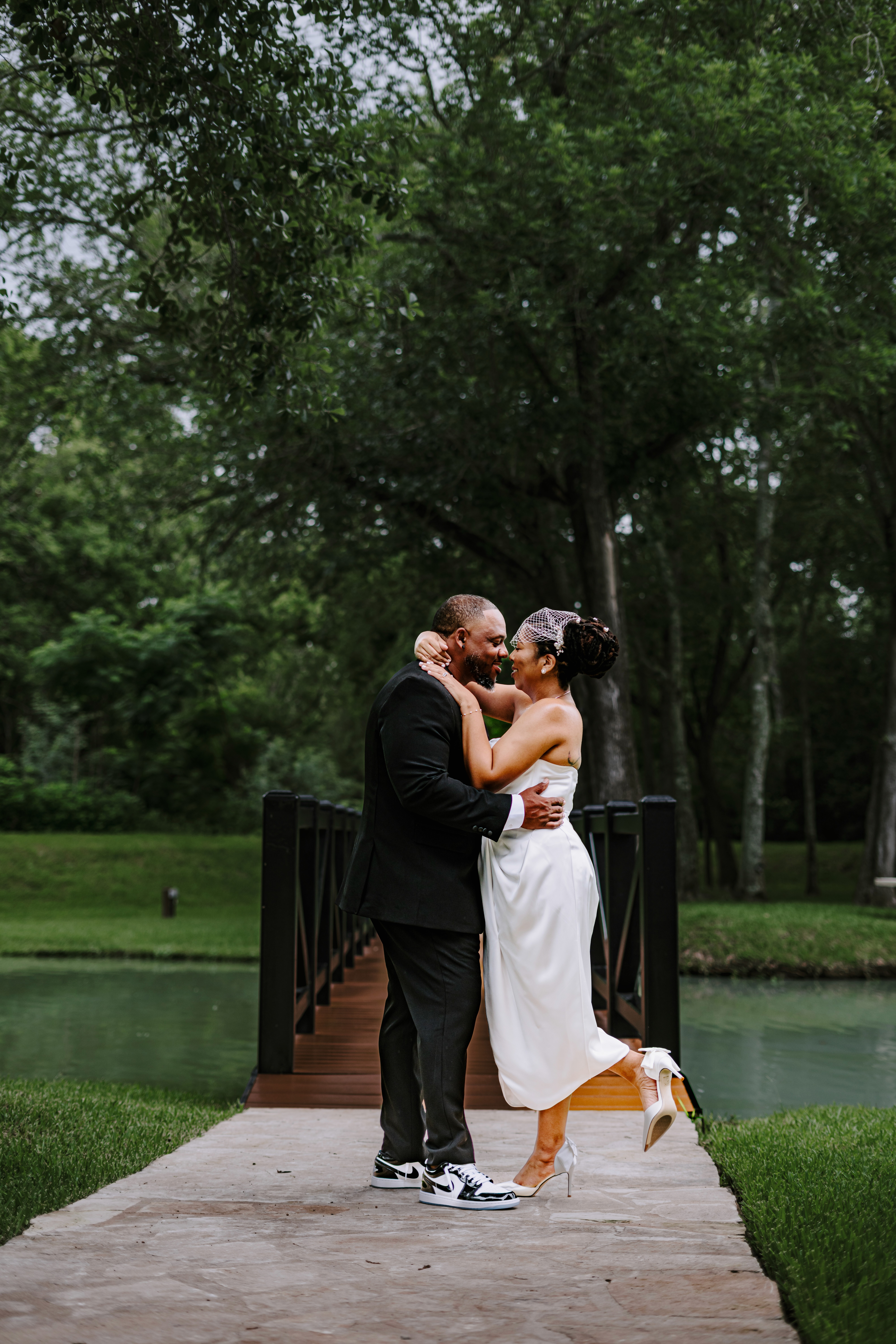 dallas biblical arts museum wedding bride and groom holding hands and spinning in front of art at the couples' portaits.