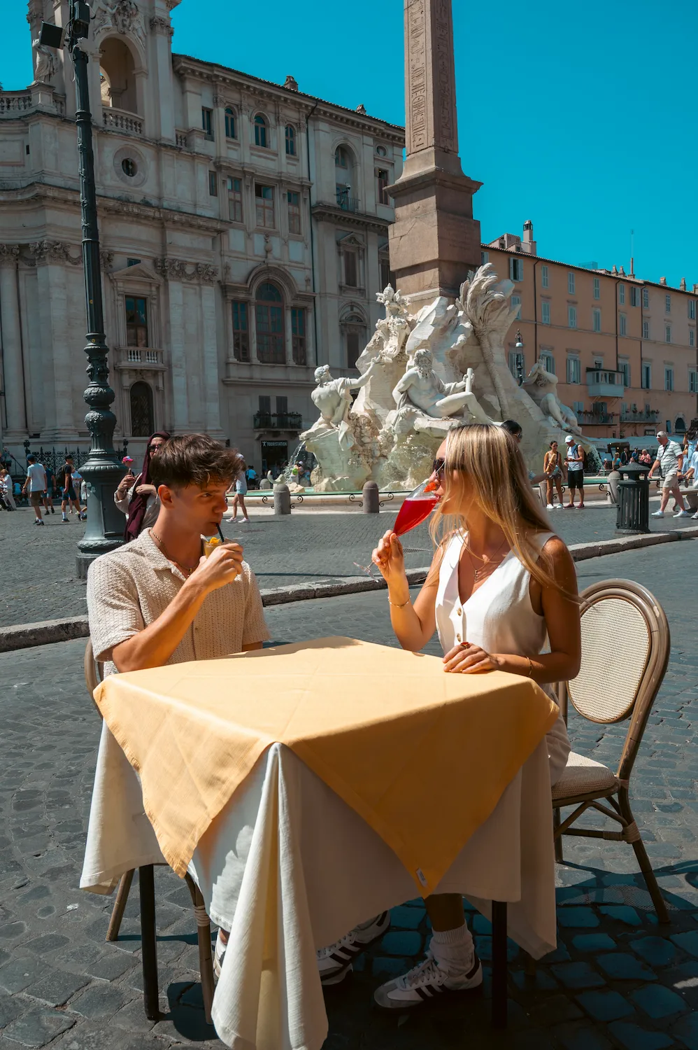 2 Ragazzi che fanno aperitivo da Tucci con dietro Piazza Navona