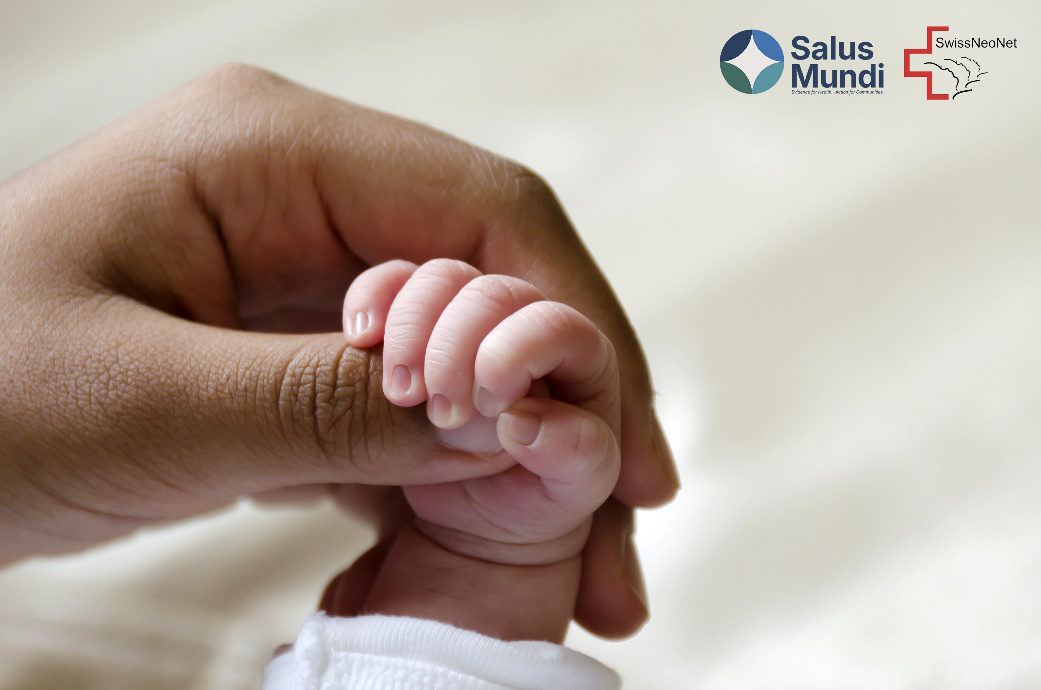 A newborn's tiny hand grasping an adult caregiver's finger, symbolising care for the most vulnerable patients in neonatal medicine.
