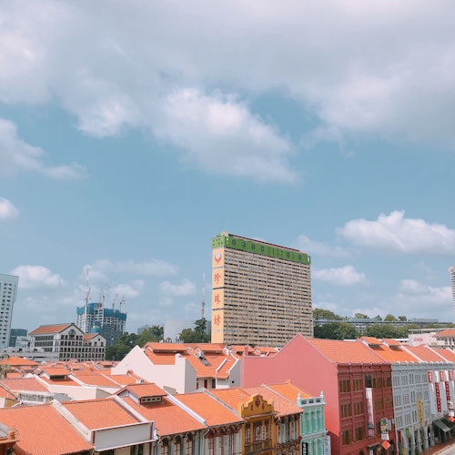 一座城市景观，前景是彩色建筑，带有红色屋顶，背景是一个高大、矩形的建筑物。