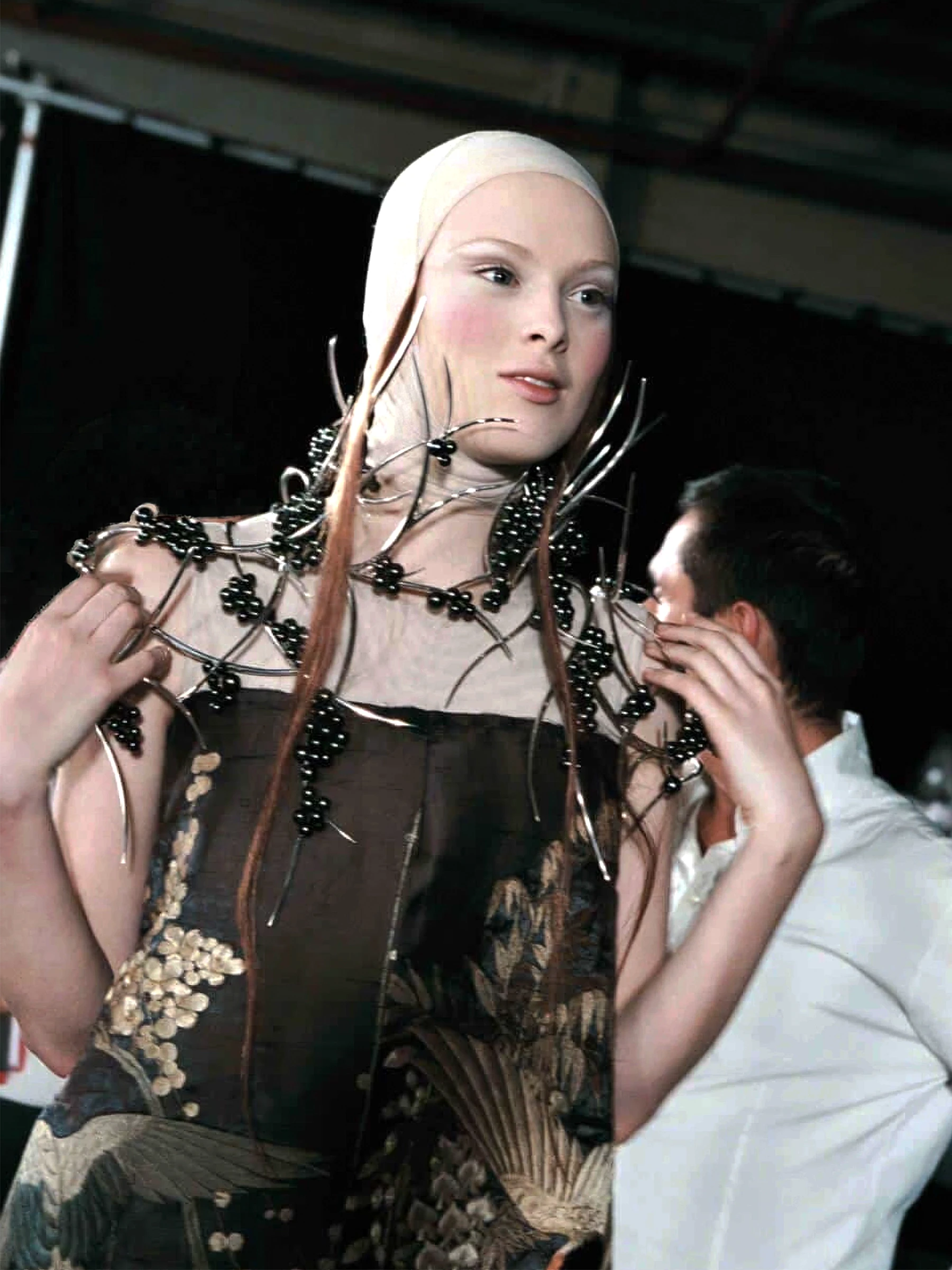 Bespoke avant-garde shoulder armour by Shaun Leane featuring silver thorns and clusters of black pearl berries, styled with a crane embroidery silk dress.