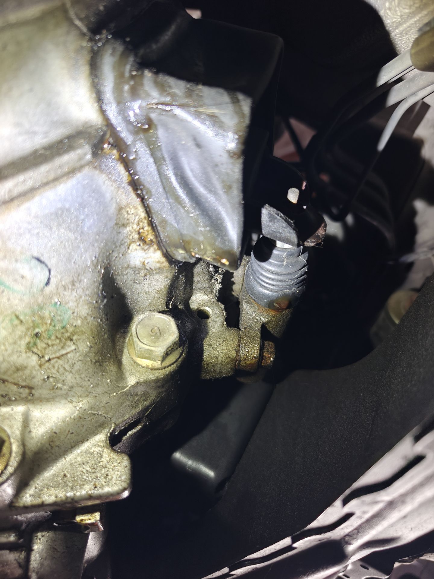 Underside of the 1992 Miata’s transmission, wet around the clutch slave cylinder and its rubber boot