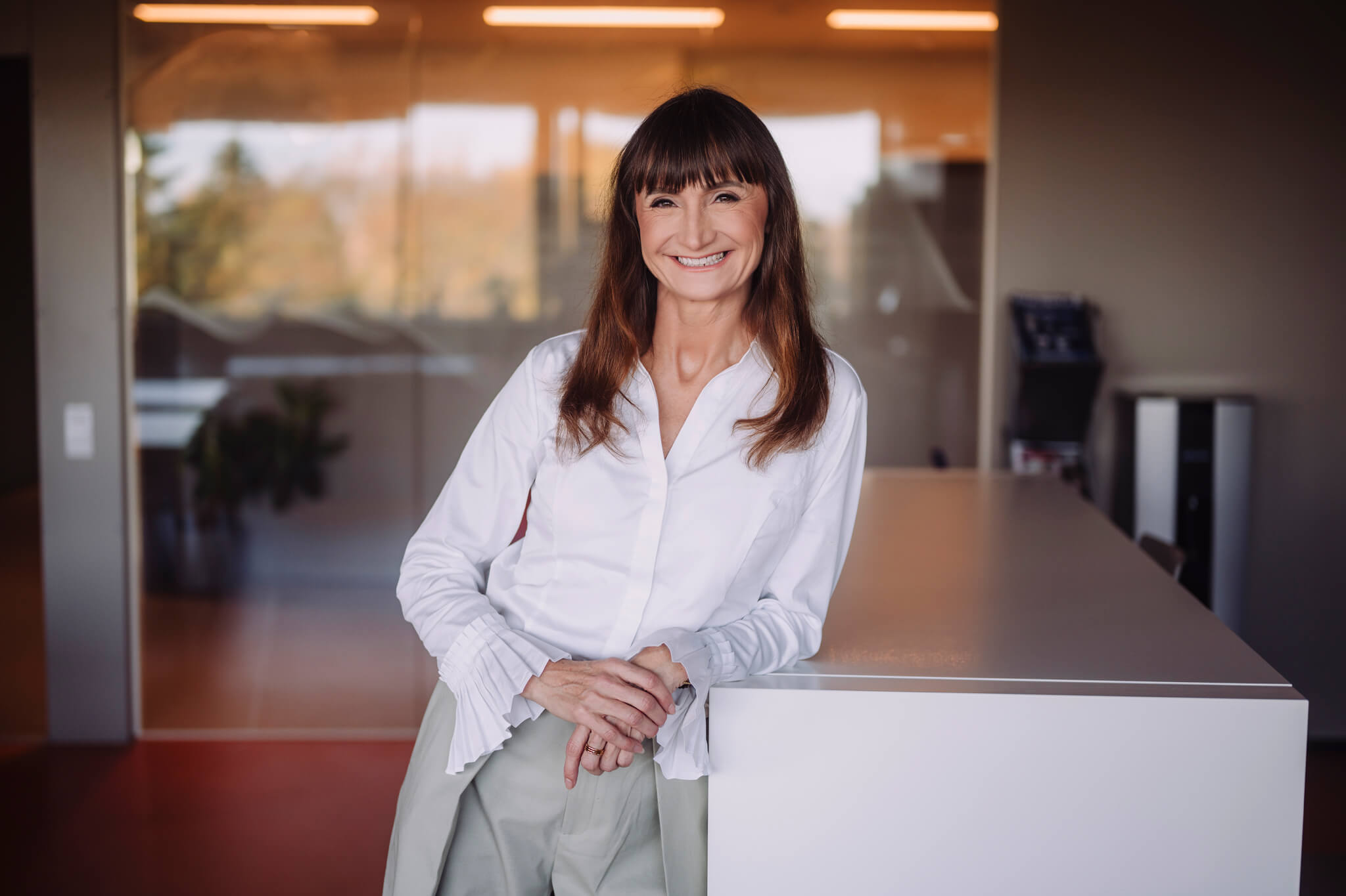 Juhtimiscoach Marika Raiski seisab naeratades modernses kontoriruumis.