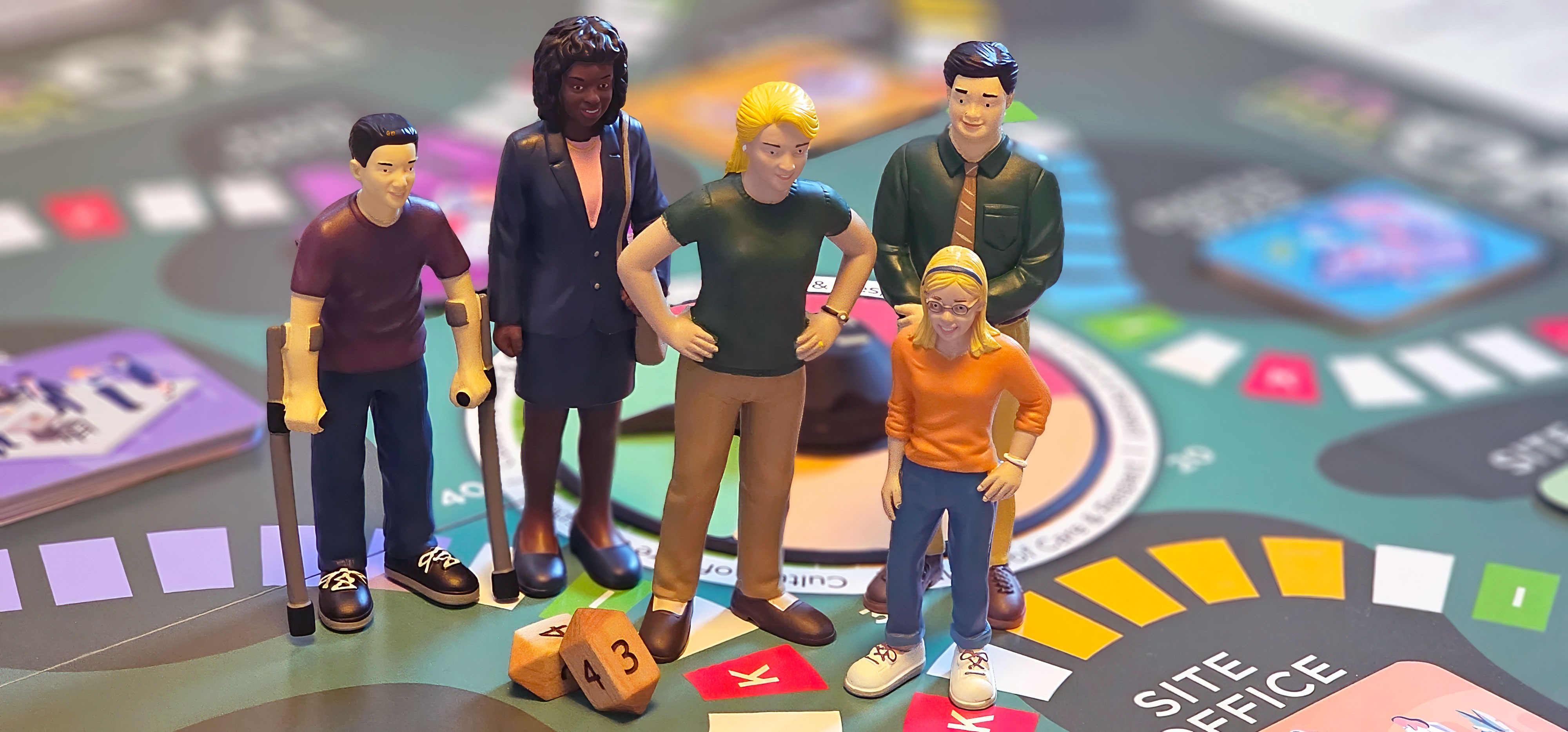 Five diverse miniature character figurines, including one using crutches, standing on a colourful workplace-themed board game near the "Site Office" square.