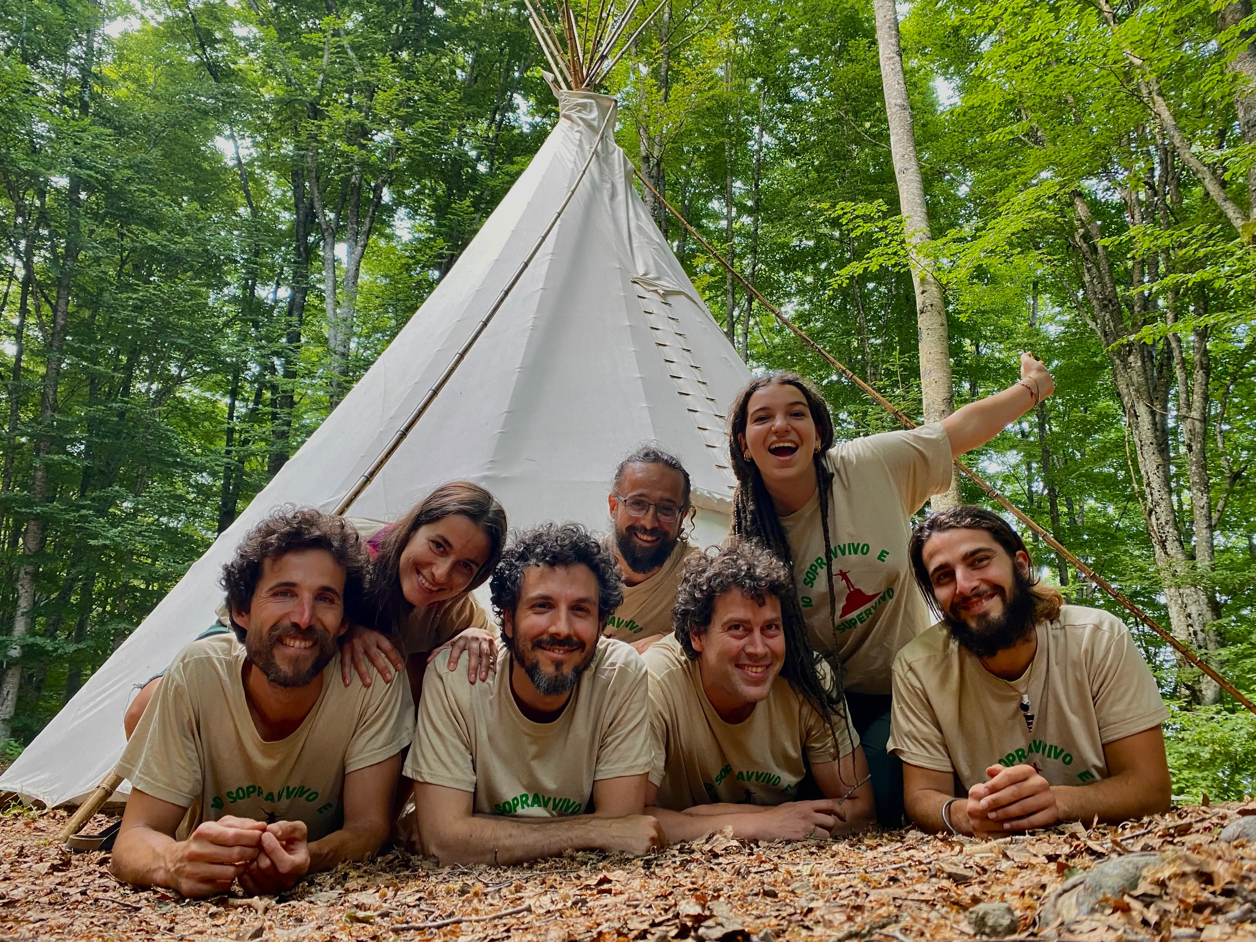 Team di educatori davanti a tipi nel bosco, esperti di outdoor education, bushcraft, corsi survival, campi estivi per ragazzi e attività di team building outdoor