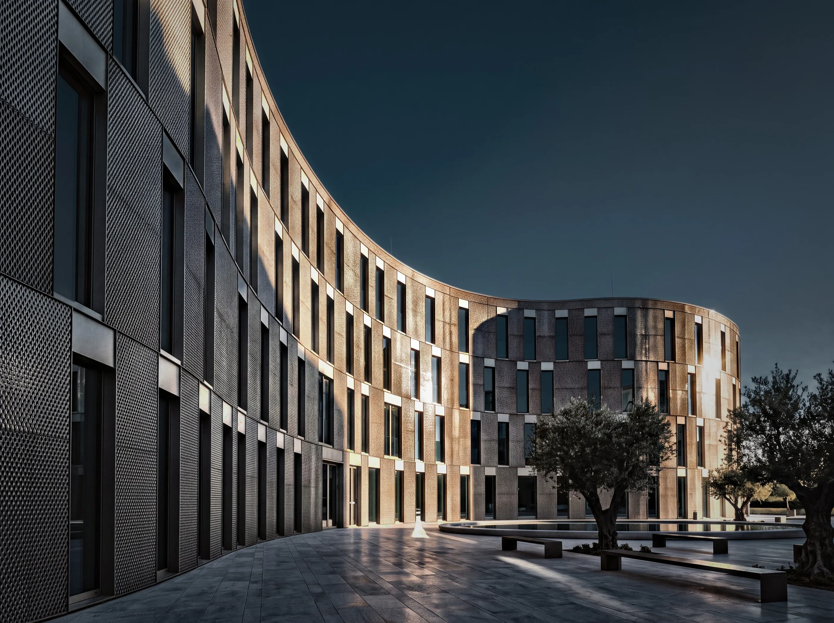 Curved brick residential block wrapped around a stone courtyard