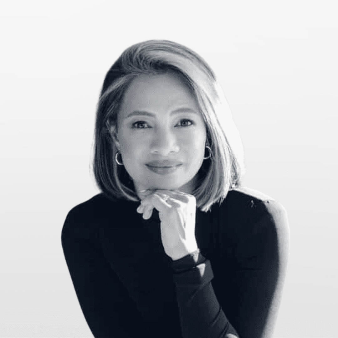 Portrait of a woman with straight long hair, in a dark t-shirt, set against a neutral backdrop.