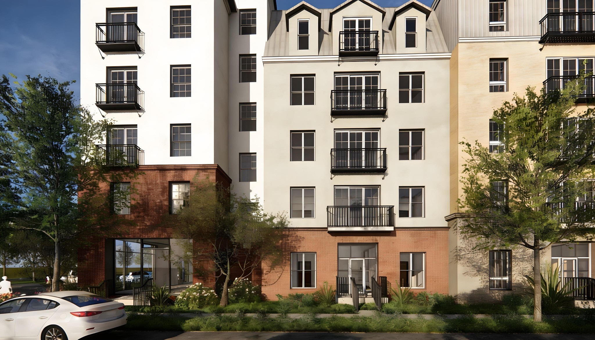 Street-level exterior of a modern three-story infill residential building with mixed facade materials including orange-red horizontal siding, grey panel cladding, and white stucco, featuring large windows, small balconies, and drought-tolerant landscaping along the sidewalk.