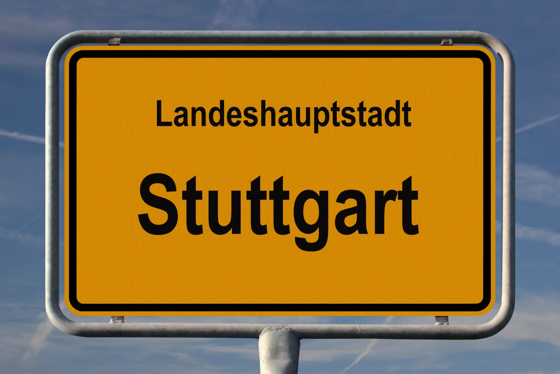 Das Stadtschild von Stuttgard im Mittelpunkt mit einem blauen und leichbewölkten Hintergrund.