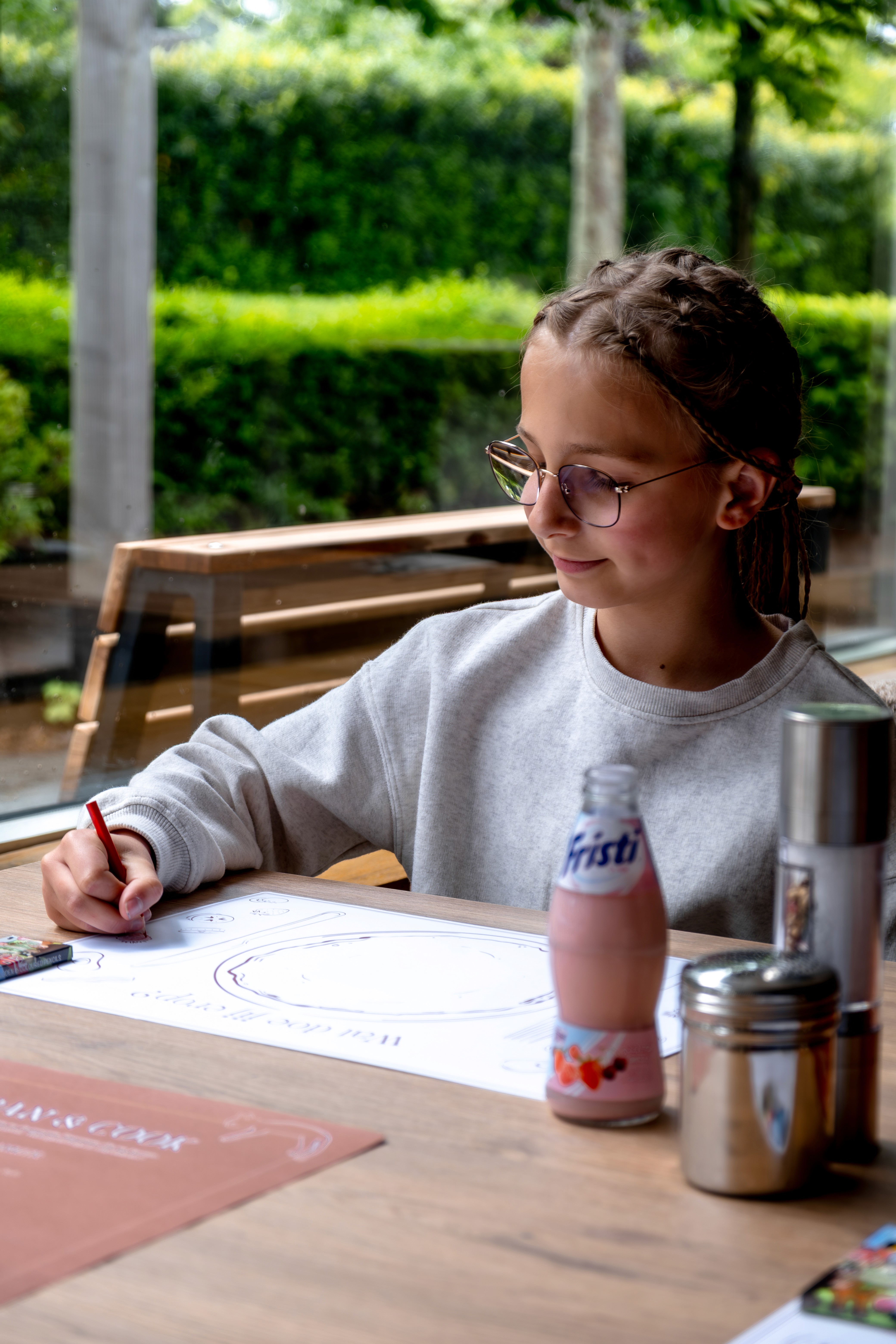Meisje kleurt de Pan & Cook placemat in aan tafel.