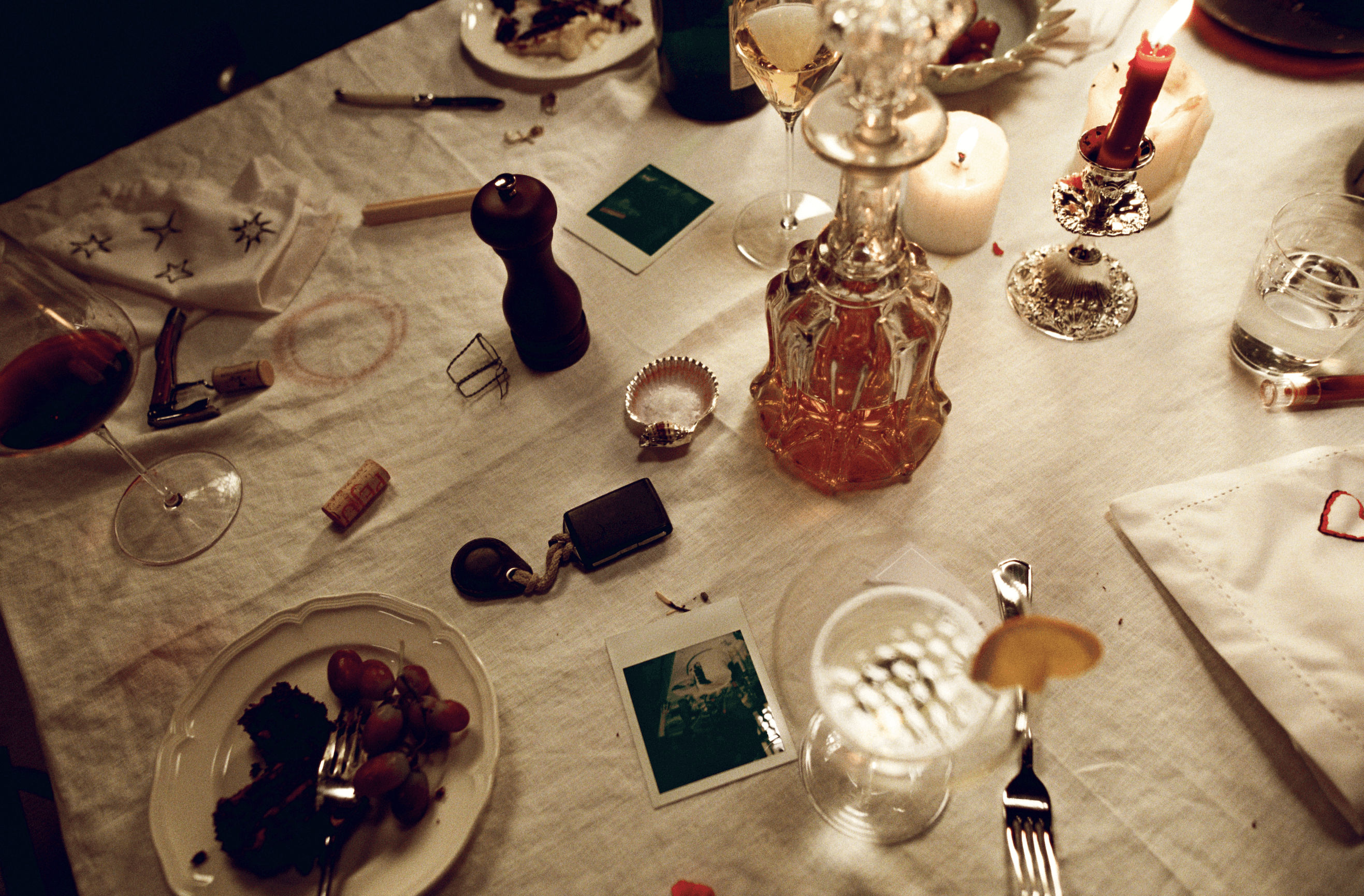 A decorated table with a floral tablecloth, featuring two vases of flowers and several blank white cards displayed behind.