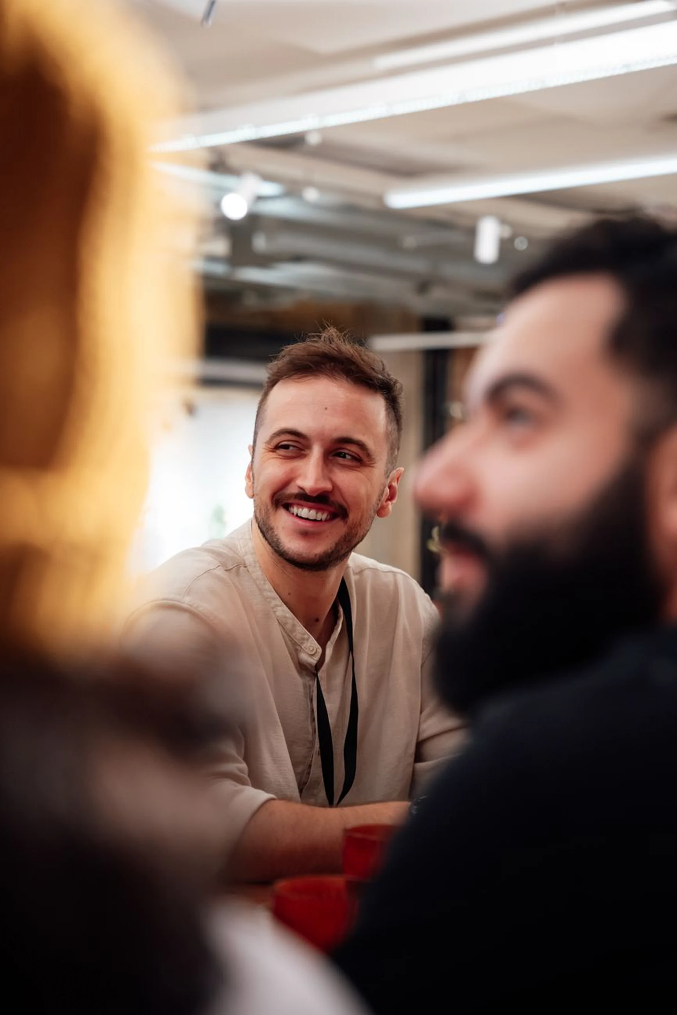 A happy male employee engaged in a collaborative team discussion. Workplace communication, corporate networking, and positive office dynamics concept.