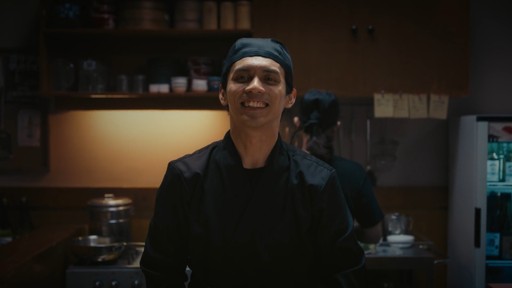 Indonesian chef smiling to customer in Tokyo kitchen setting in cinematic brand film for DCOM Money Express, produced by Visual Producer Indonesia