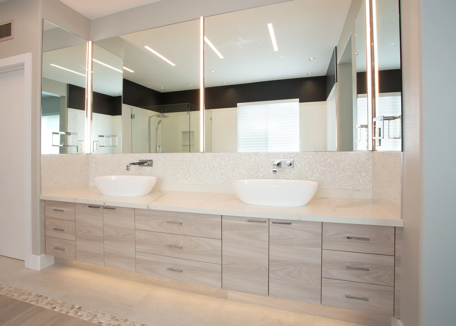 View from angle 1 of the master bath's double vanity, featuring sleek design and high-end finishes in the Harbor Cove remodel.