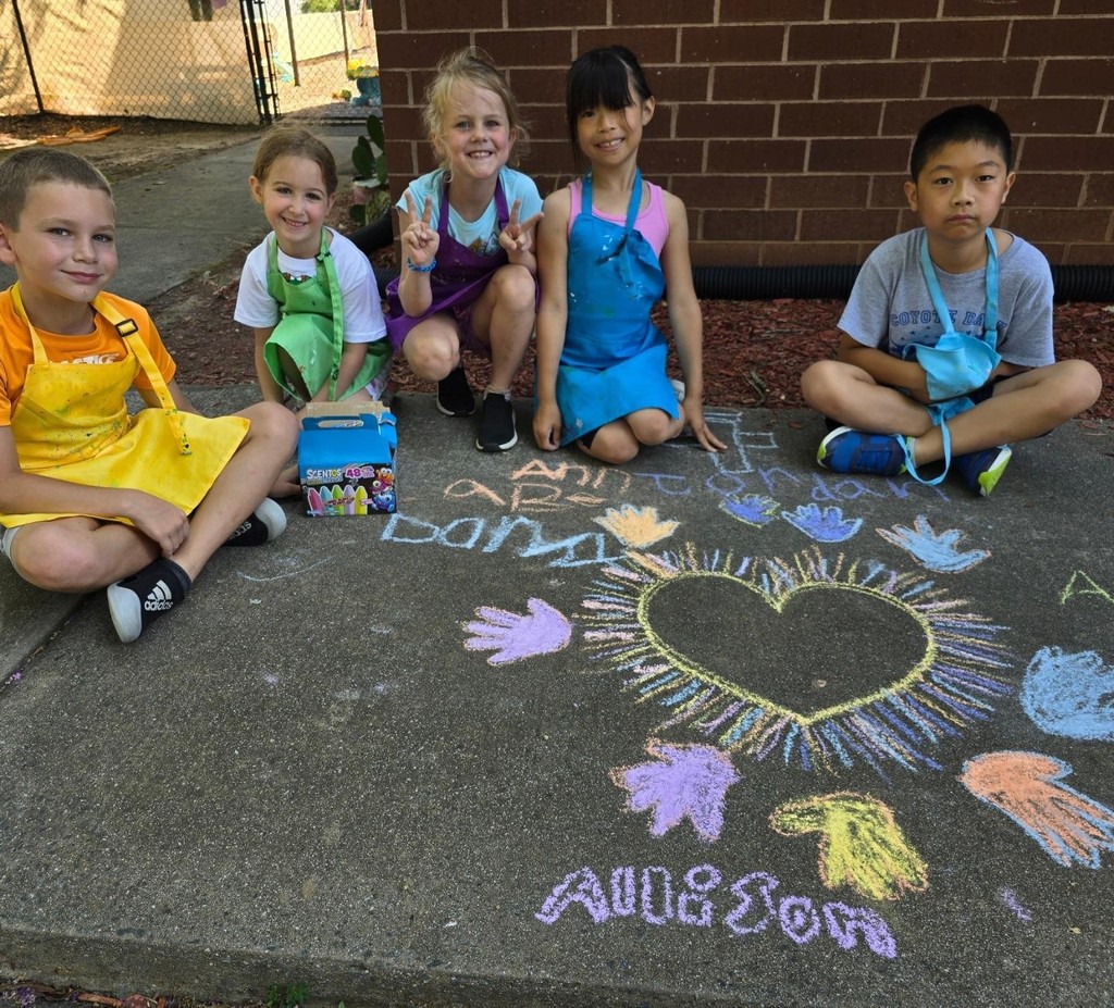 Summer campers doing sidewalk art outside of the SportPlus Charlotte facility 