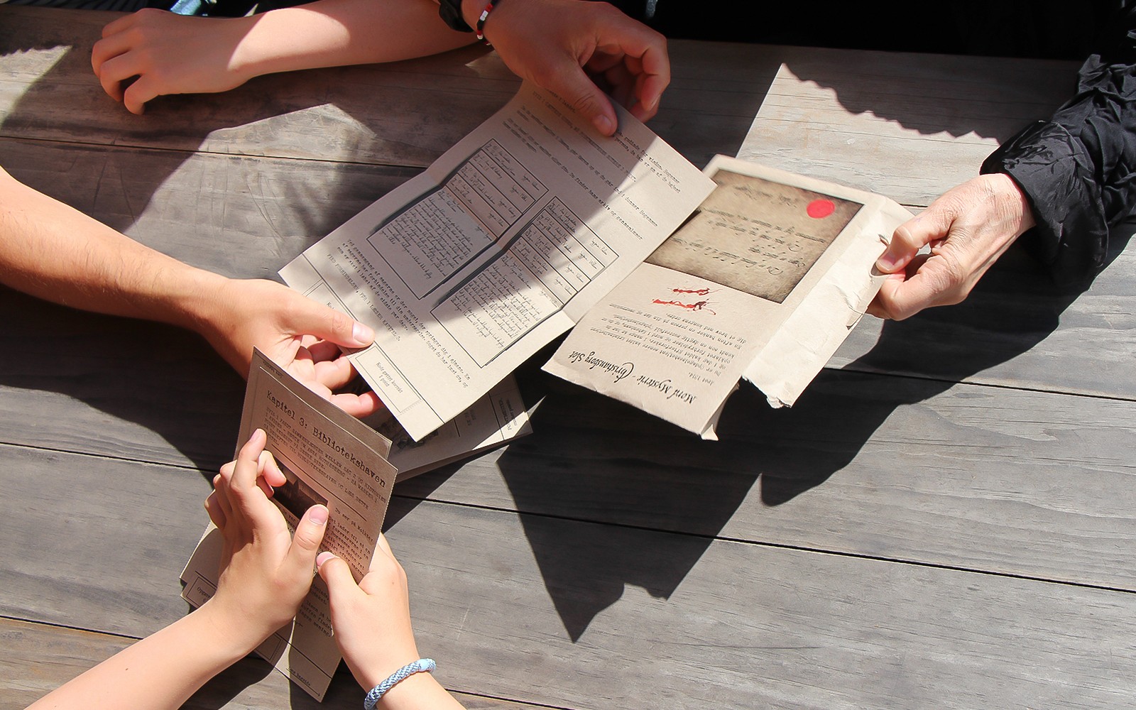 Participants examining mystery documents during Nyhavn adventure in Copenhagen.